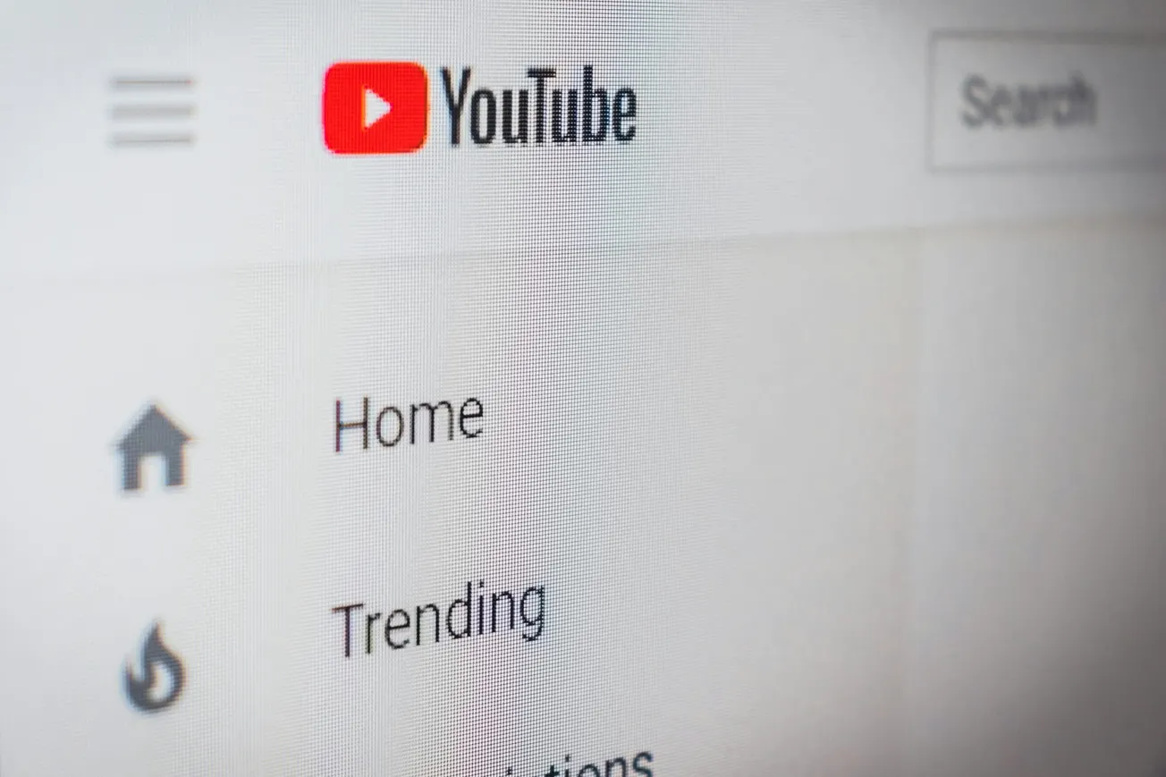 Close-up of a YouTube webpage showing the logo and menu options: Home, Trending. The interface is minimalistic and focused on navigation.