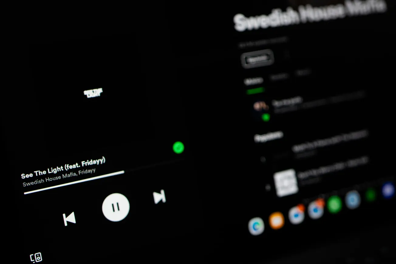 Close-up of a dark-themed music app interface displaying "See The Light" by Swedish House Mafia. The play button is highlighted, evoking a modern vibe.