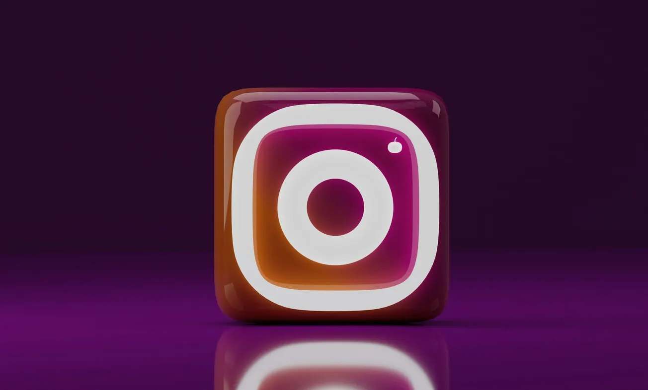 3D-rendered Instagram logo with a glossy finish, set against a dark purple background. The logo’s vibrant gradient reflects against a polished surface.