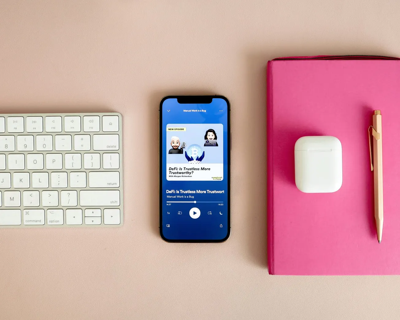 A smartphone displays a podcast screen titled "DeFi: Is Trustless More Trustworthy?" with a keyboard on the left and a pink notebook, AirPods, and a pen on the right.