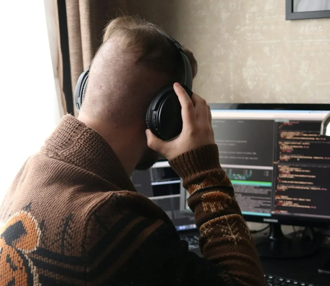 A content creator meticulously edits audio waveforms on a digital audio workstation, wearing professional studio headphones to ensure optimal sound quality for their project.