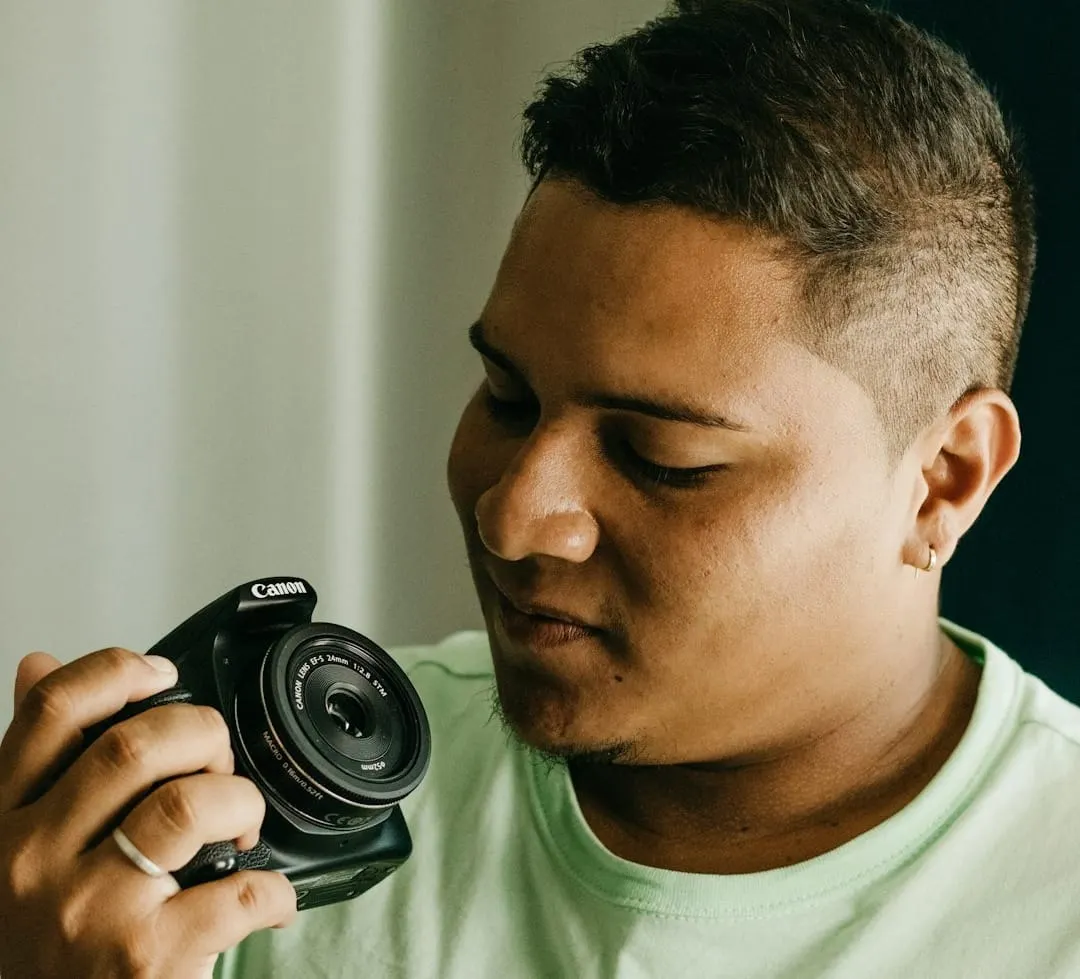 A smiling person captures a moment with an easy-to-use compact digital camera, emphasizing accessible visual content creation for all.