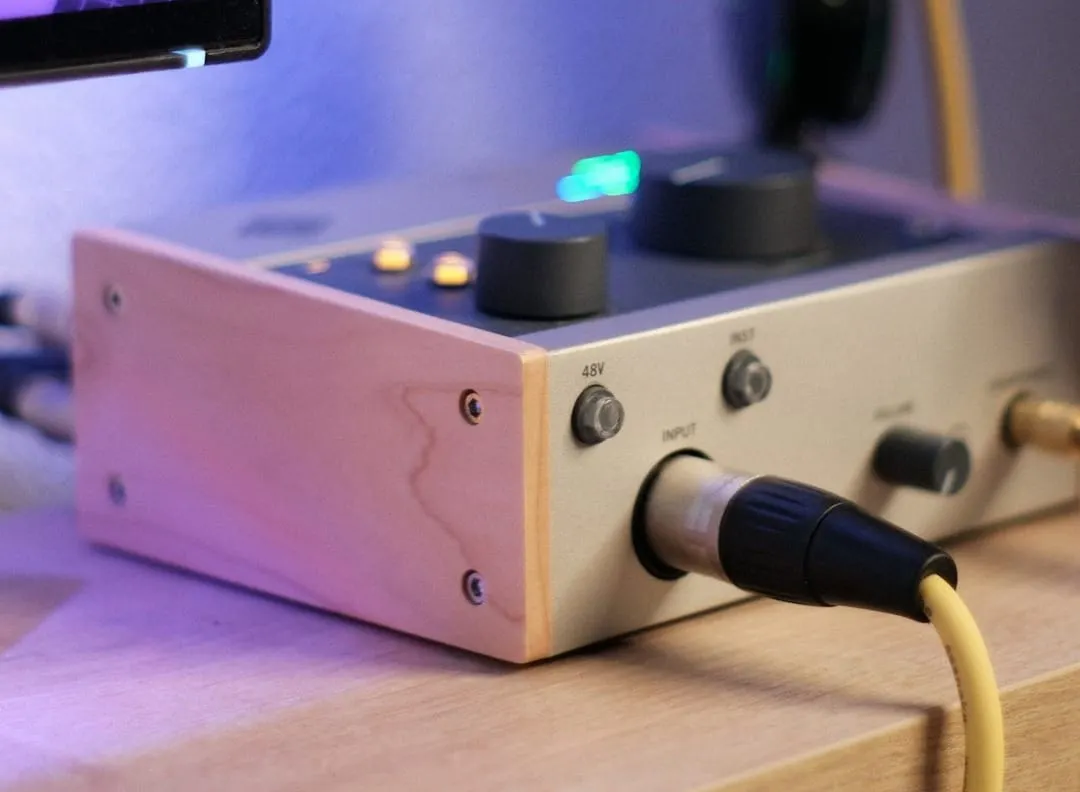 A classic solid-state amplifier connected to professional studio headphones on a desk, ready for detailed audio monitoring.