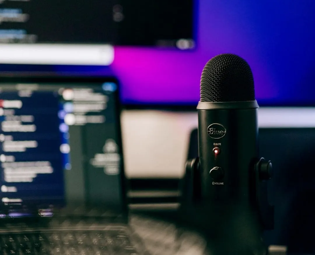 A vintage microphone stands next to a contemporary podcasting setup, symbolizing the blend of past lessons and modern content creation.