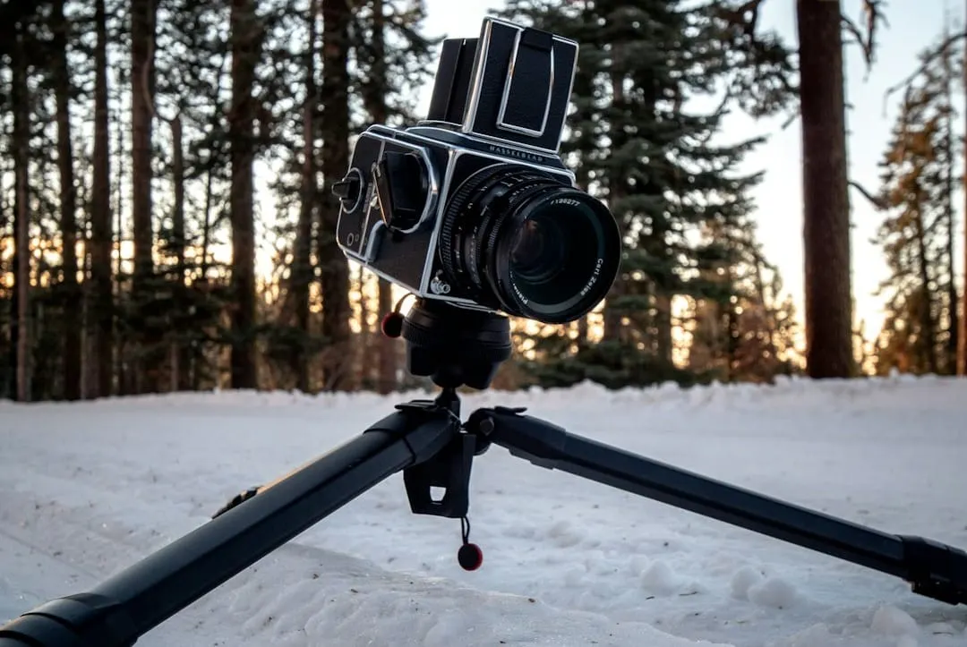 A photographer effortlessly attaches a mirrorless camera equipped with the modular Peak Design Field Bracket and a cold shoe mount to a tripod, demonstrating efficient video workflow.