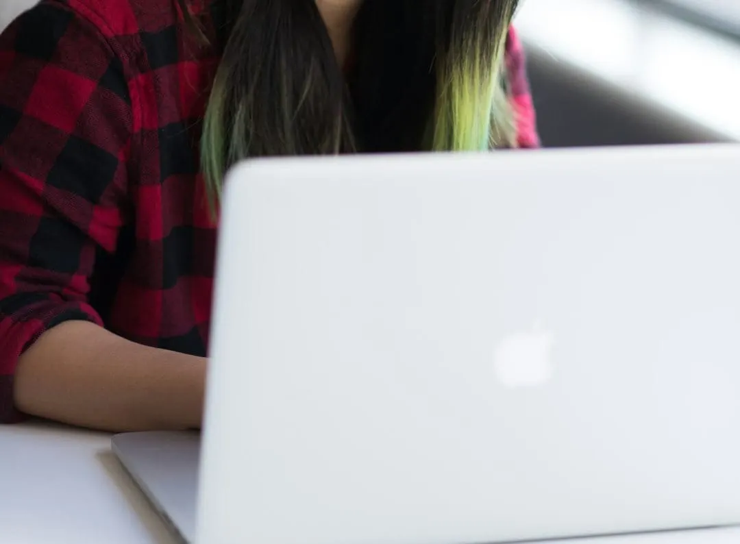A focused user with headphones navigates a website on a laptop, highlighting web accessibility improvements within a content management system.