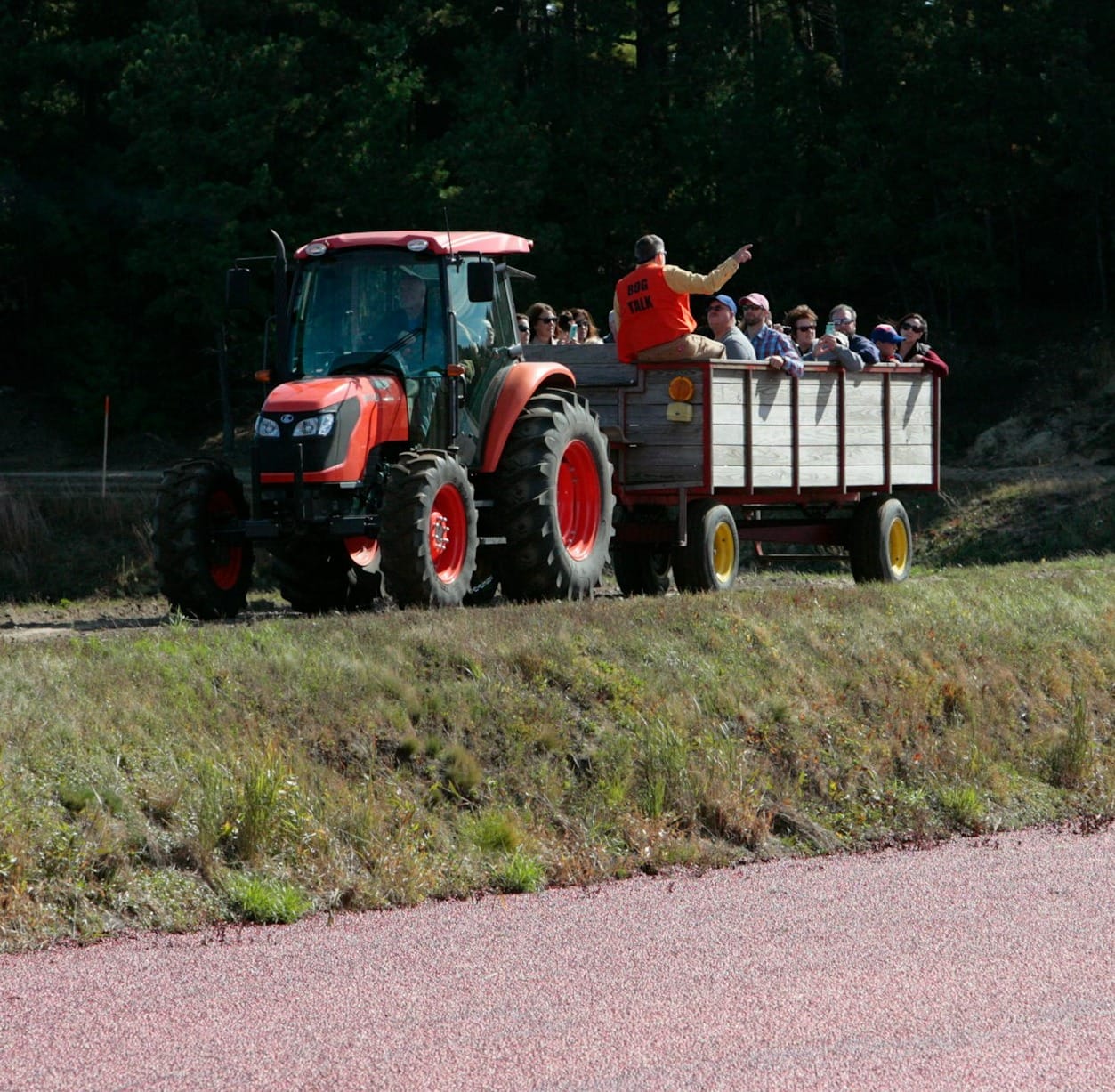 a tractor pulling a trailer filled with people
