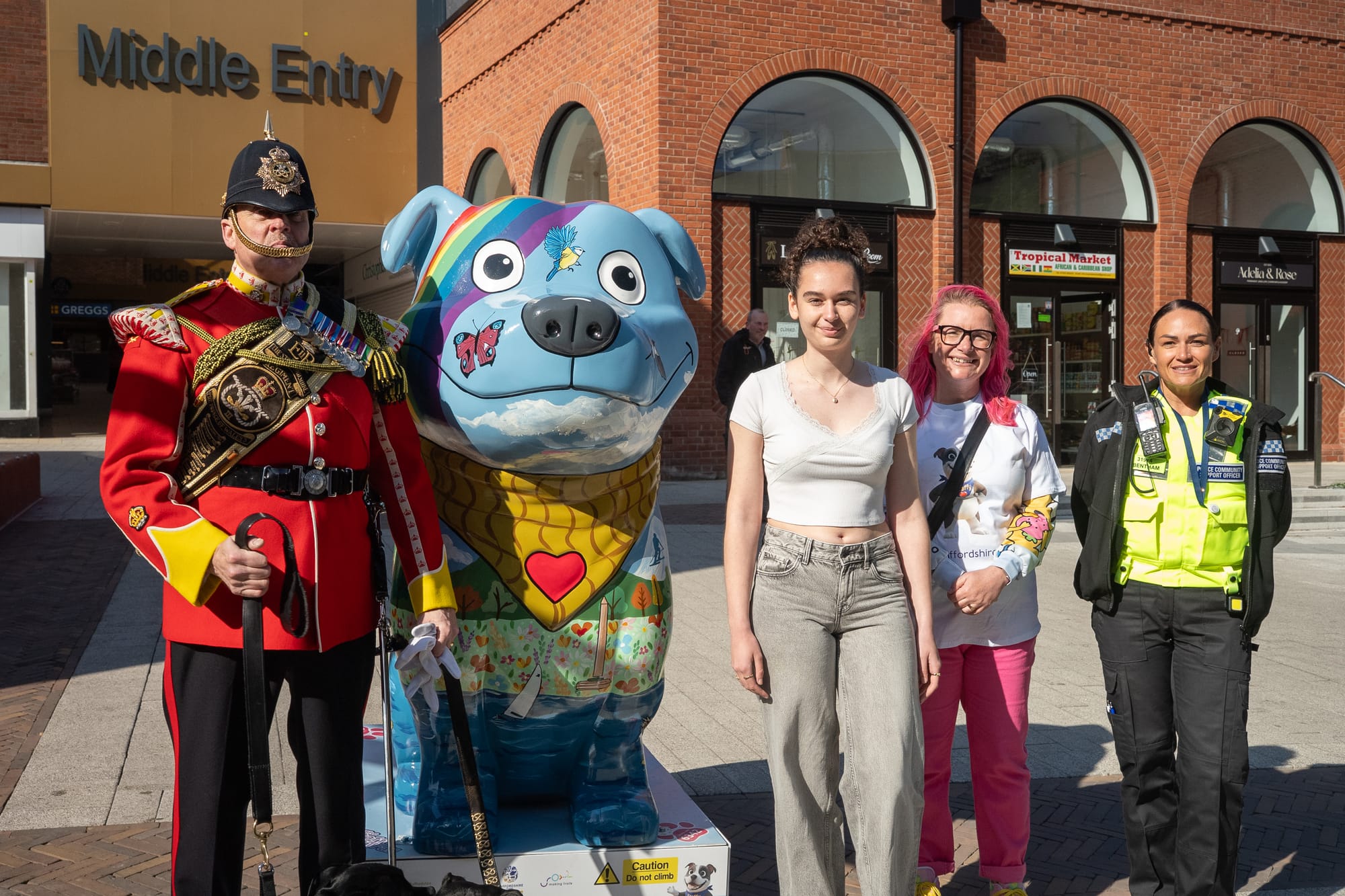 Handler Greg Hedges with Sgt Watchman VI, 'Clay' Staffy Sculpture, competition winner Amy Stokes who helped to create Clay, artist Carla Dee, and a PCSO