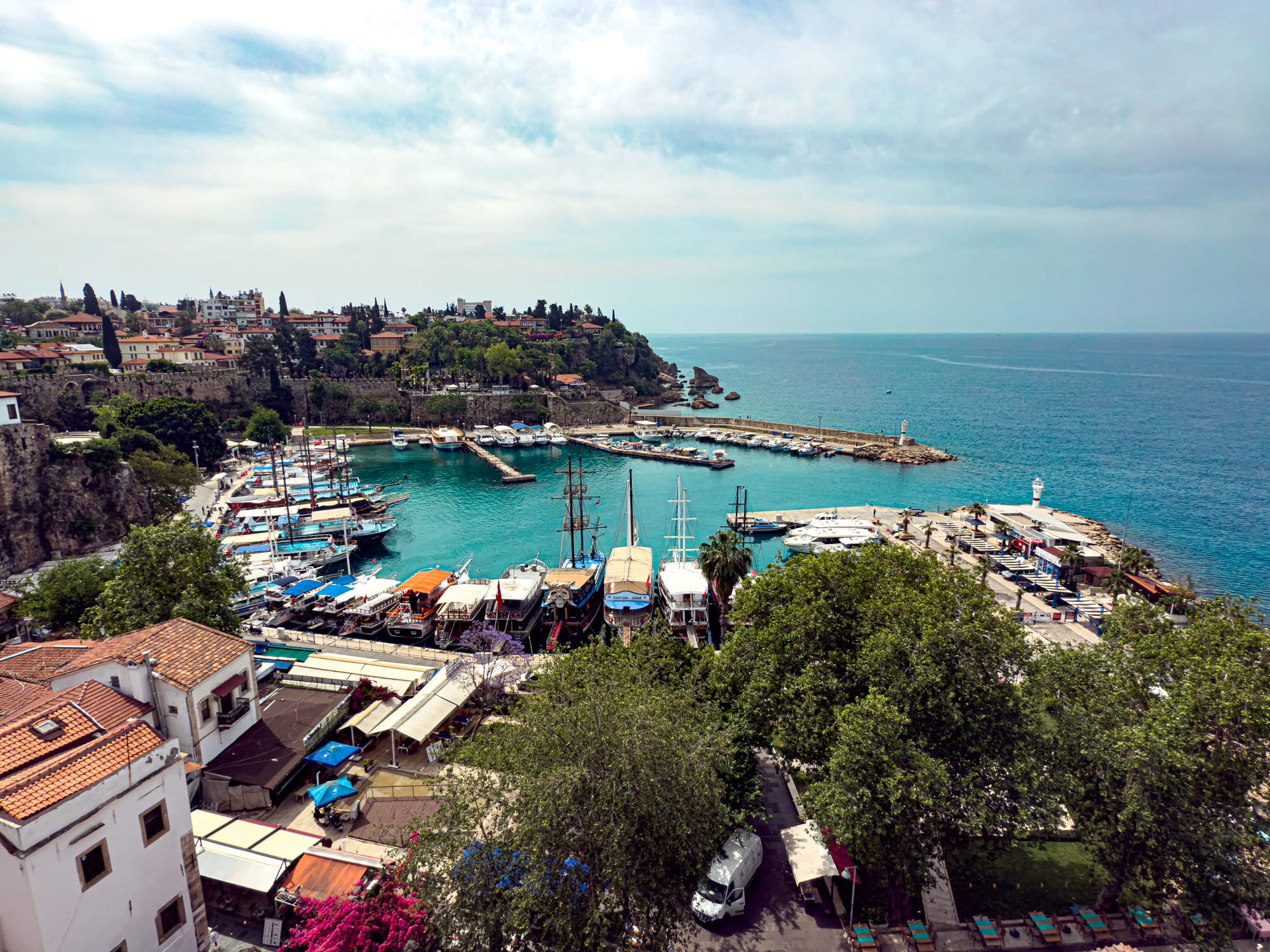View overlooking Kaleiçi’s marina in Antalya, with moored sailboats, terracotta rooftops, and the turquoise sea