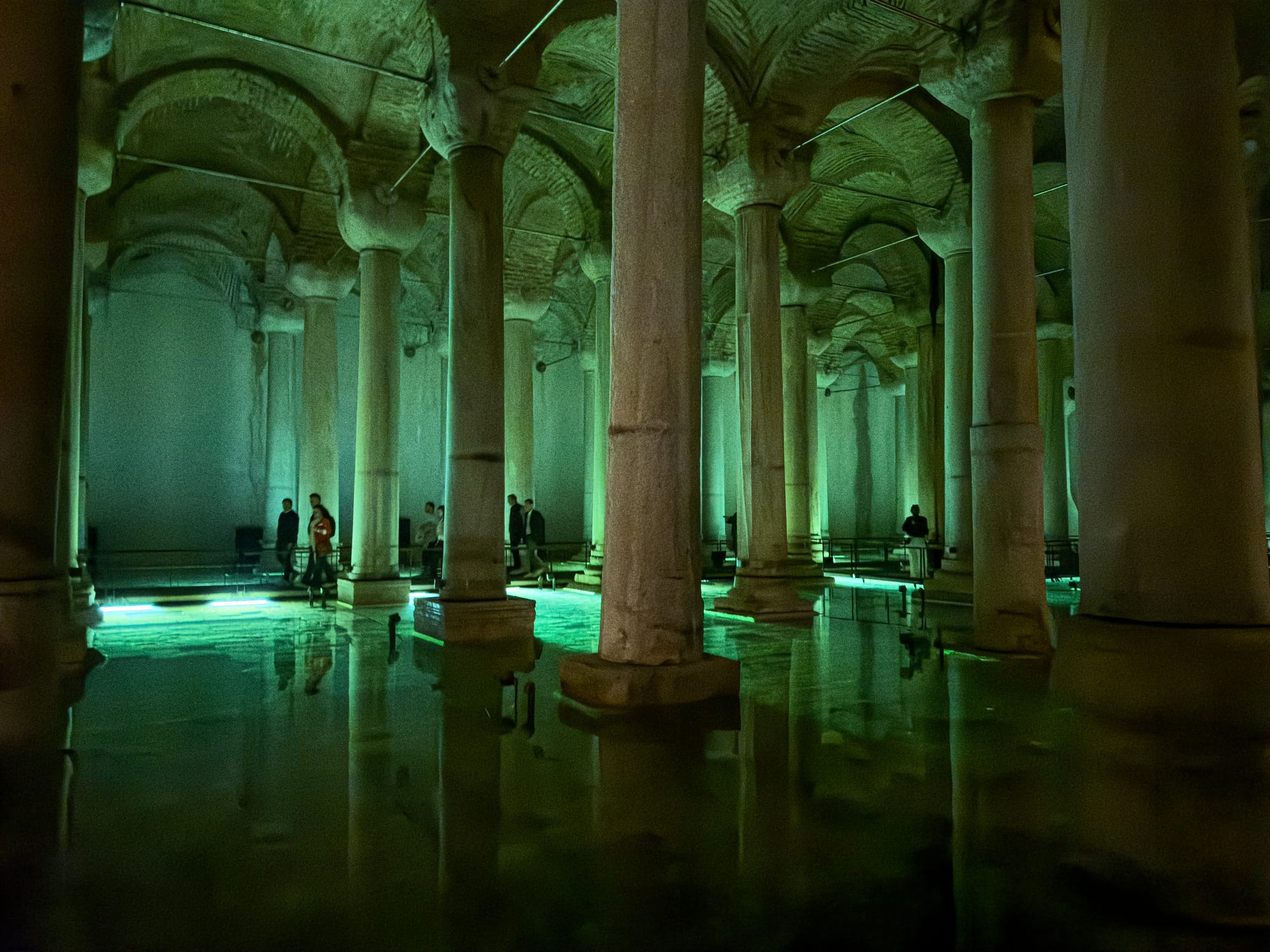 Interior of the Basilica Cistern with blue-green lighting reflecting on water and surrounding columns