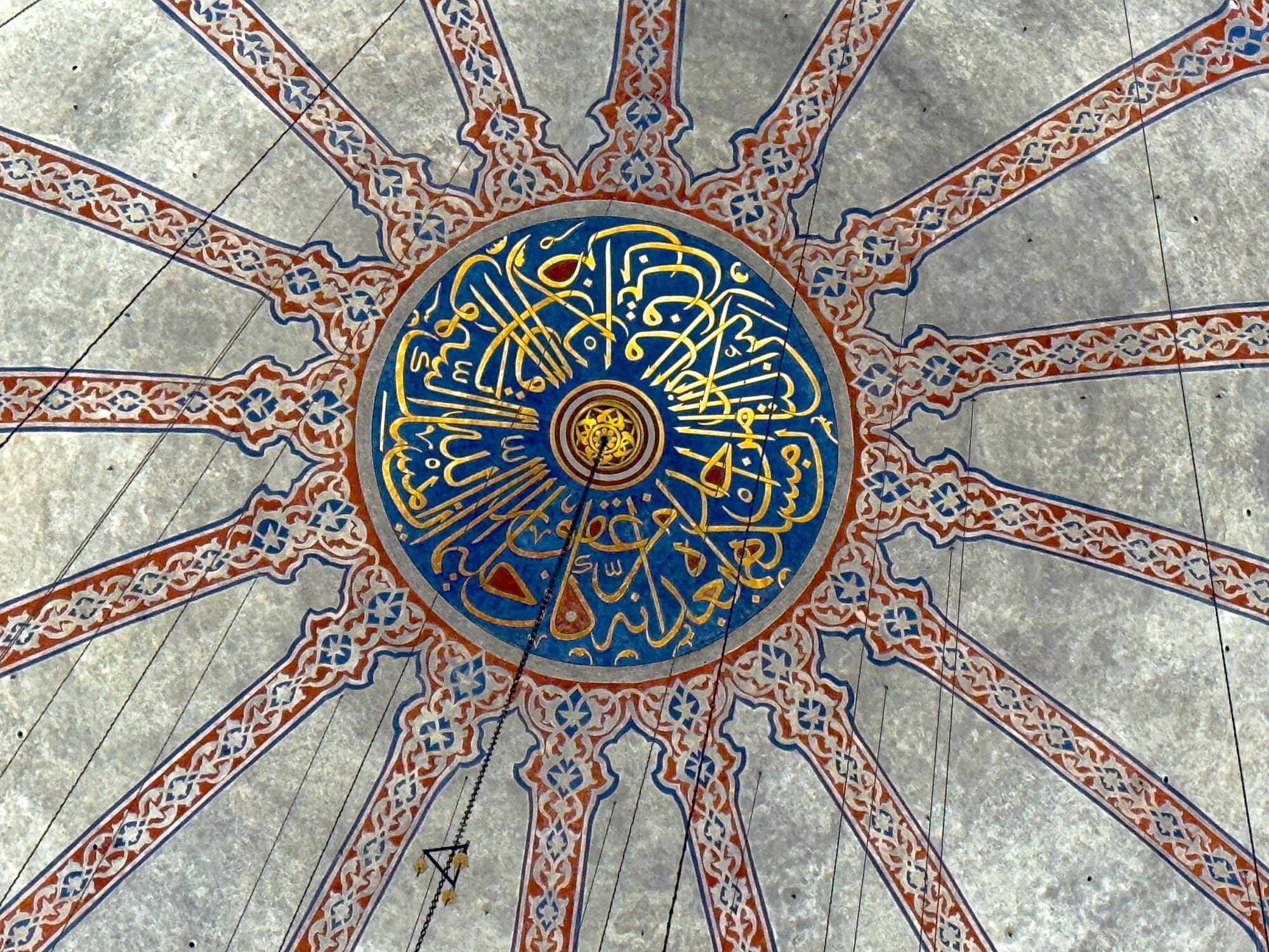 Close-up of the central dome of the Blue Mosque, featuring intricate Arabic calligraphy in gold and blue