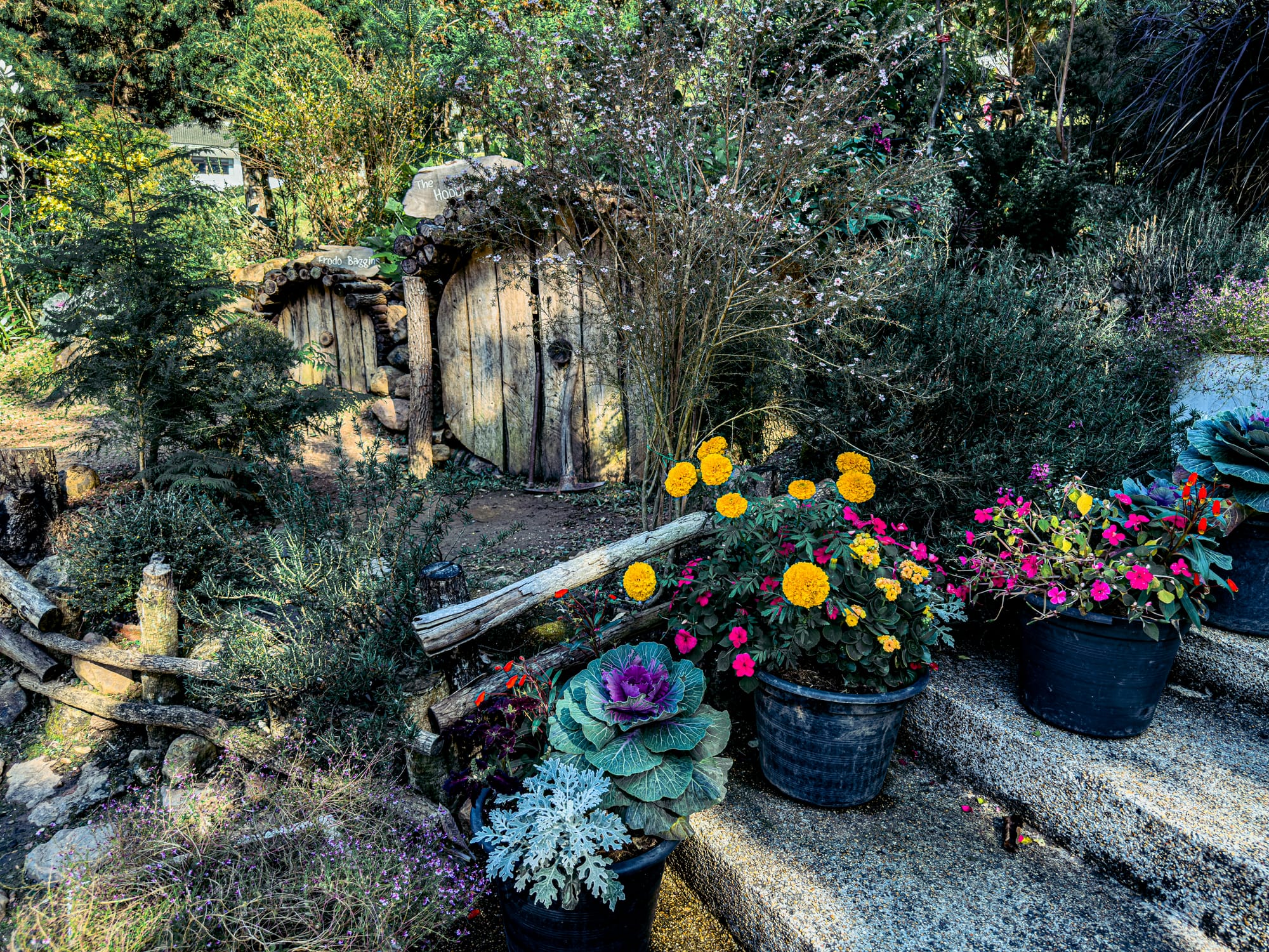 Hobbit house-style garden display with colorful flowers and plants at Queen Sirikit Botanic Garden, Mae Rim, Thailand