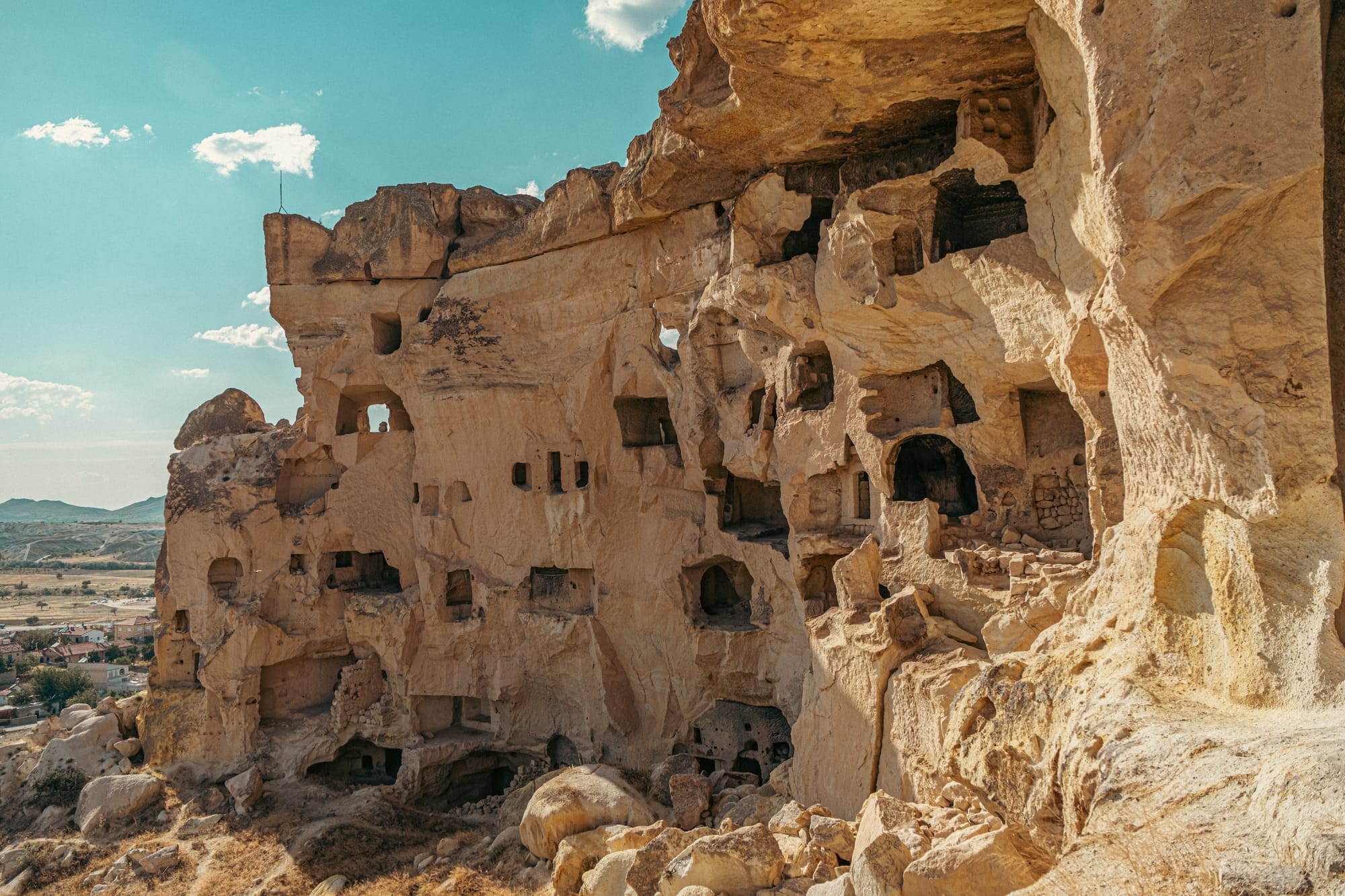 Close-up view of Çavuşin Castle in Cappadocia showing eroded rock formations with multiple carved cave dwellings and openings