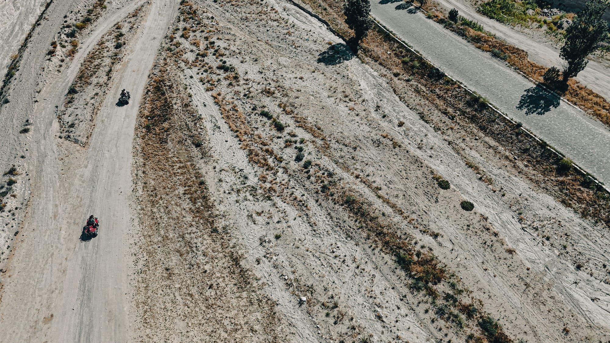 Aerial view of ATV riders navigating dirt trails near Çavuşin in Cappadocia, Turkey