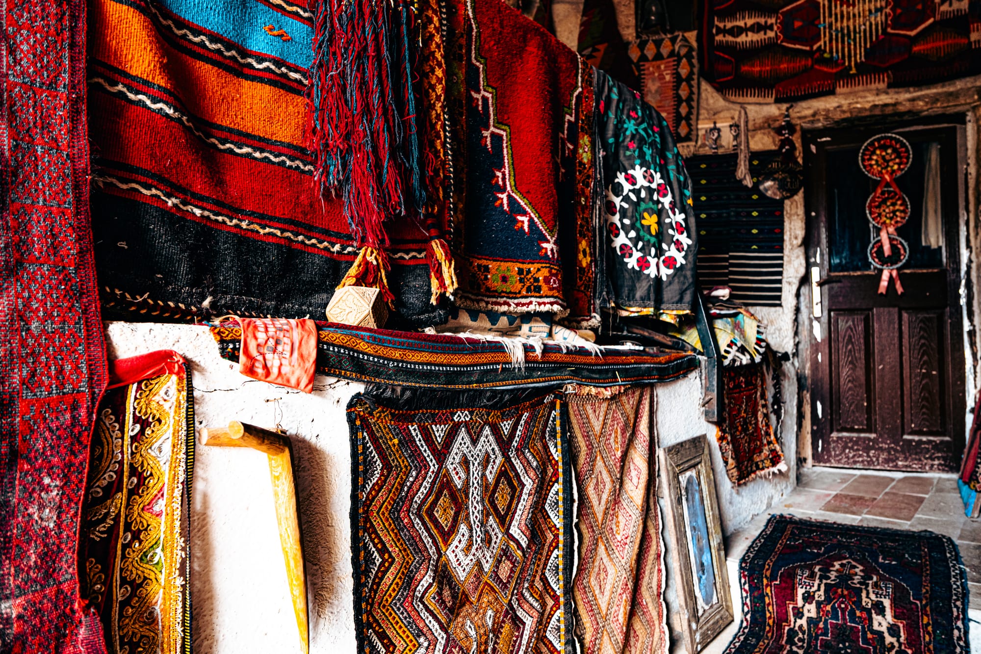 Colorful woven rugs and traditional Turkish textiles hanging on display at Cappadocia Cultural Antique Collection