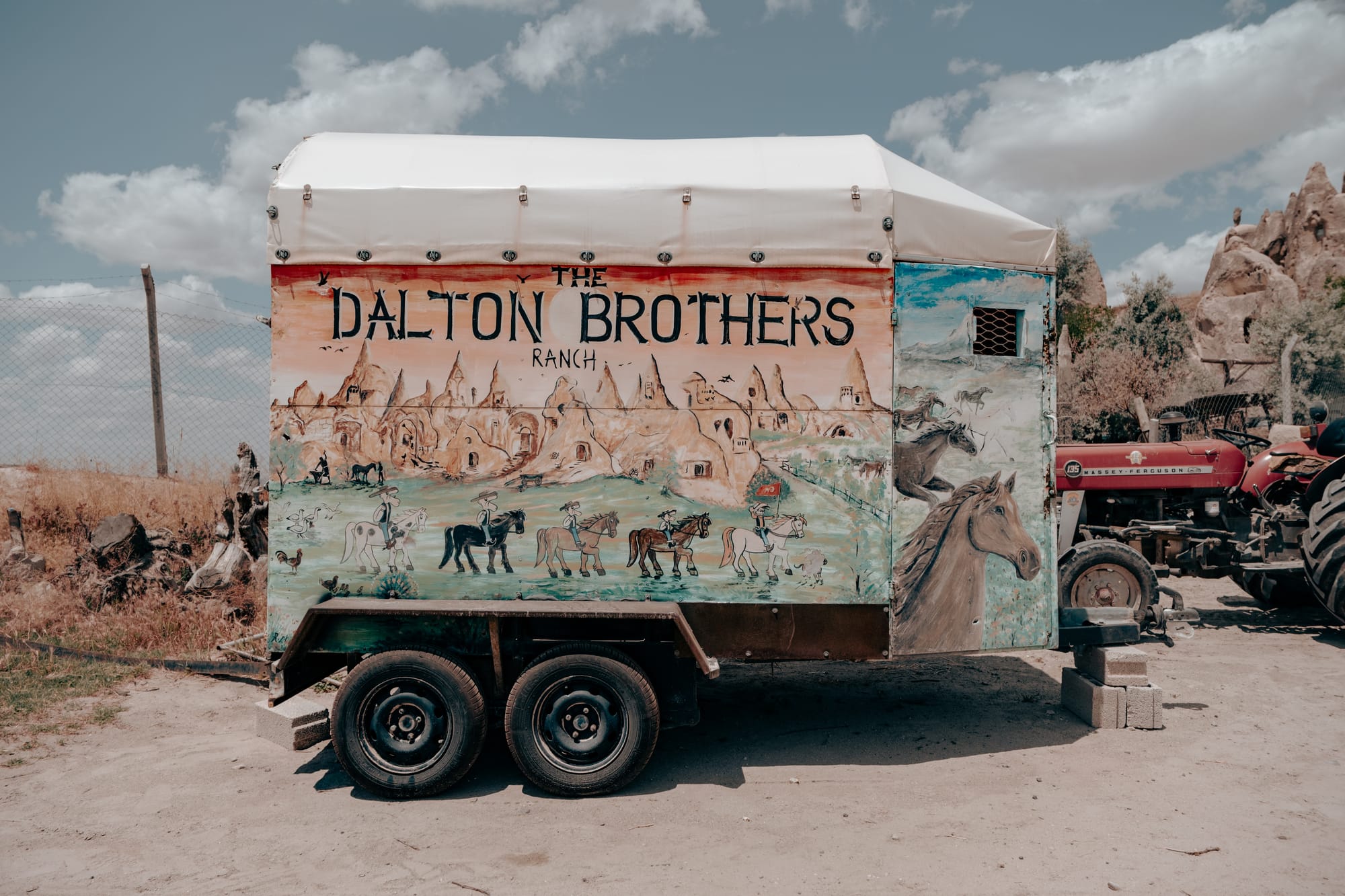 Colorful hand-painted trailer at Dalton Brothers Ranch in Cappadocia, Turkey, depicting horses, cowboys, and the region’s famous fairy chimneys, embodying the rustic charm and cultural heritage of the area