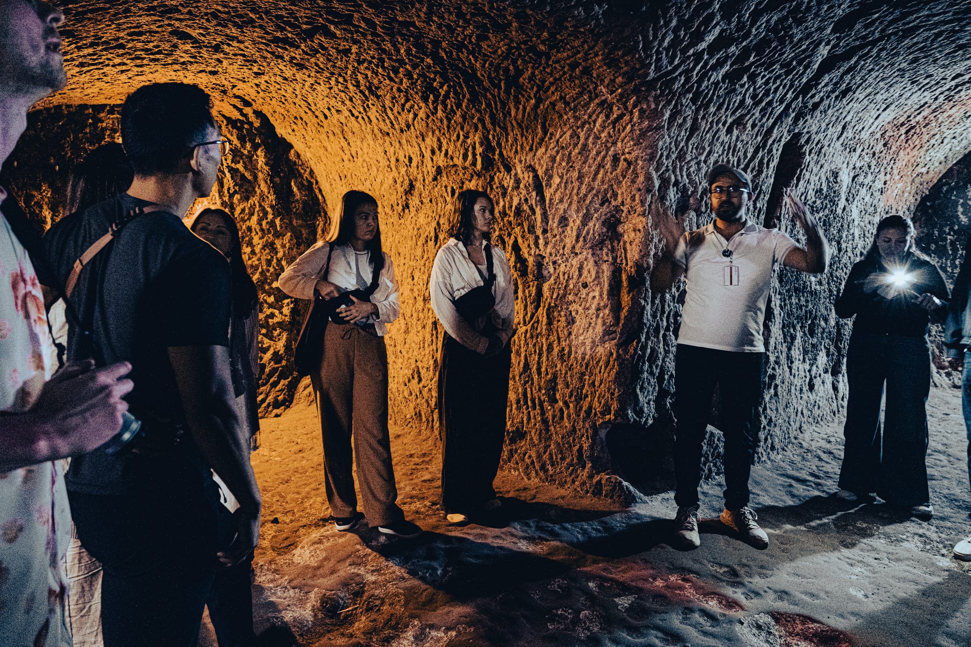 Tour guide explaining the history of Derinkuyu Underground City to visitors inside its carved rock tunnels