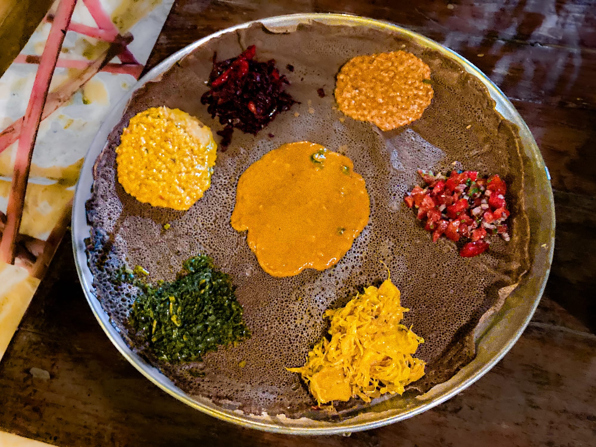 A colorful Ethiopian vegan platter served on injera at Tribearth