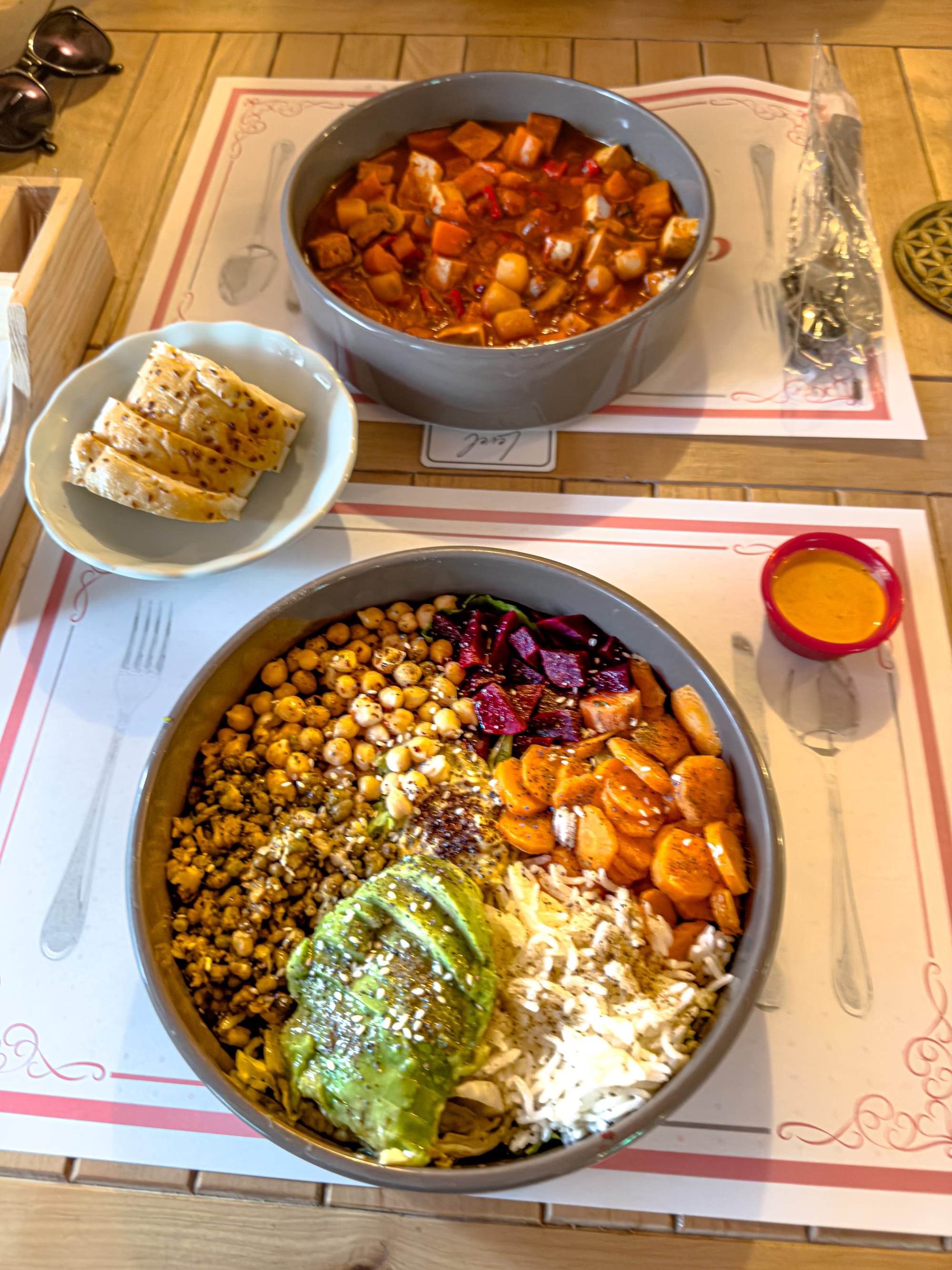 Colorful vegan meal at Level Vegan and Gluten-Free Restaurant in Antalya featuring a Buddha bowl with avocado, chickpeas, beets, carrots, and rice, alongside a bowl of vegetable goulash