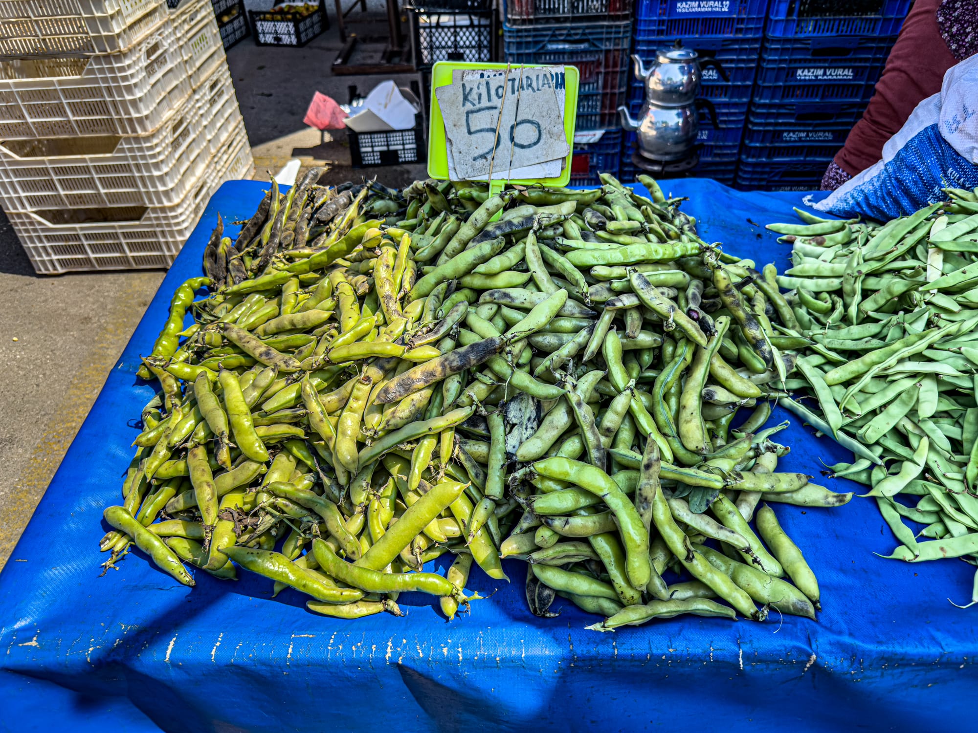 Fire-roasted broad beans for sale at Antalya’s Friday Market with handwritten price sign