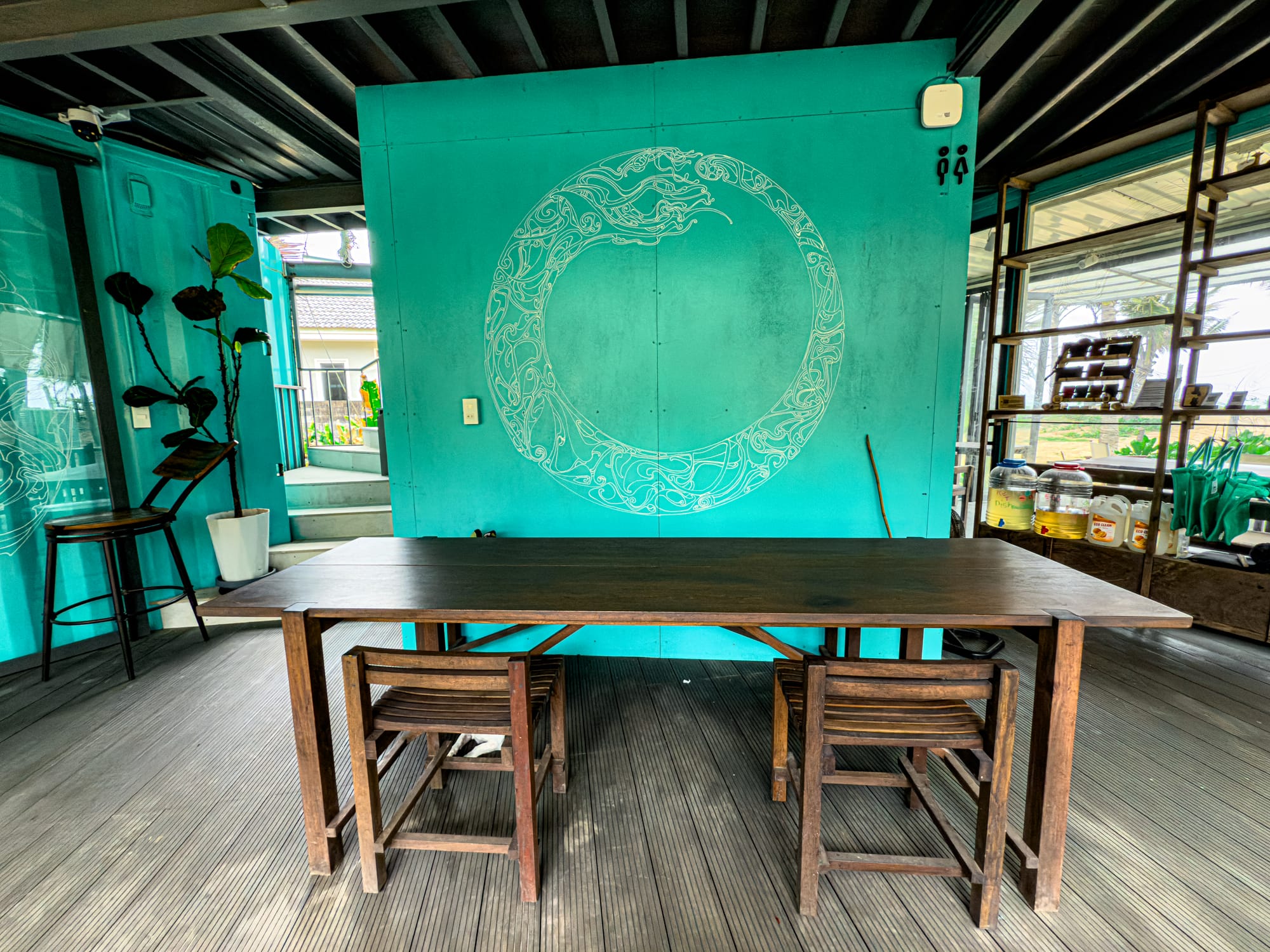 Indoor coworking table at Hít Hà Cafe in Hội An with turquoise wall design for digital nomads and remote workers