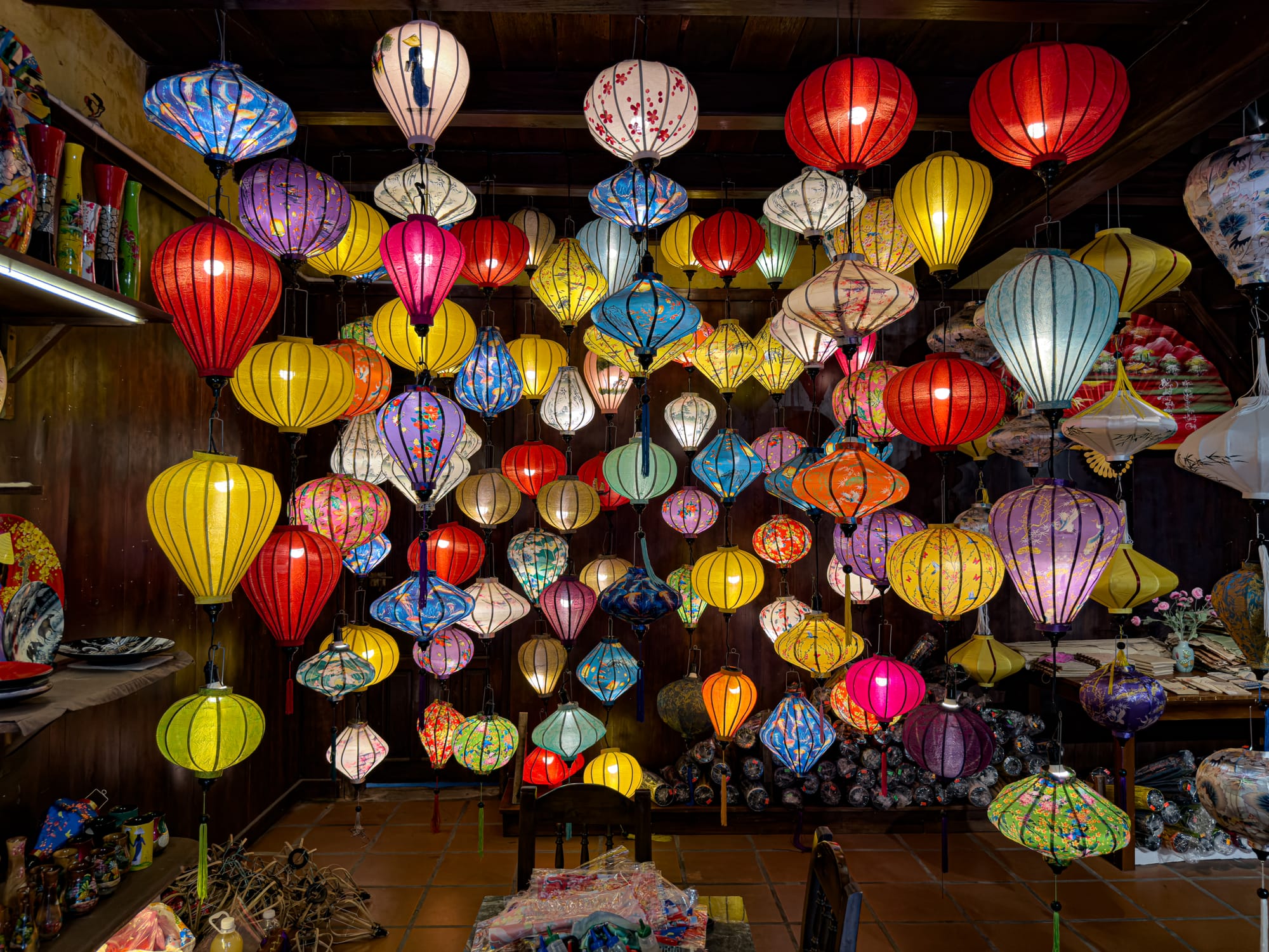 Traditional silk lanterns in vibrant colors displayed inside a shop in Hội An’s Old Town, Vietnam, showcasing the town’s famous lantern craft and heritage