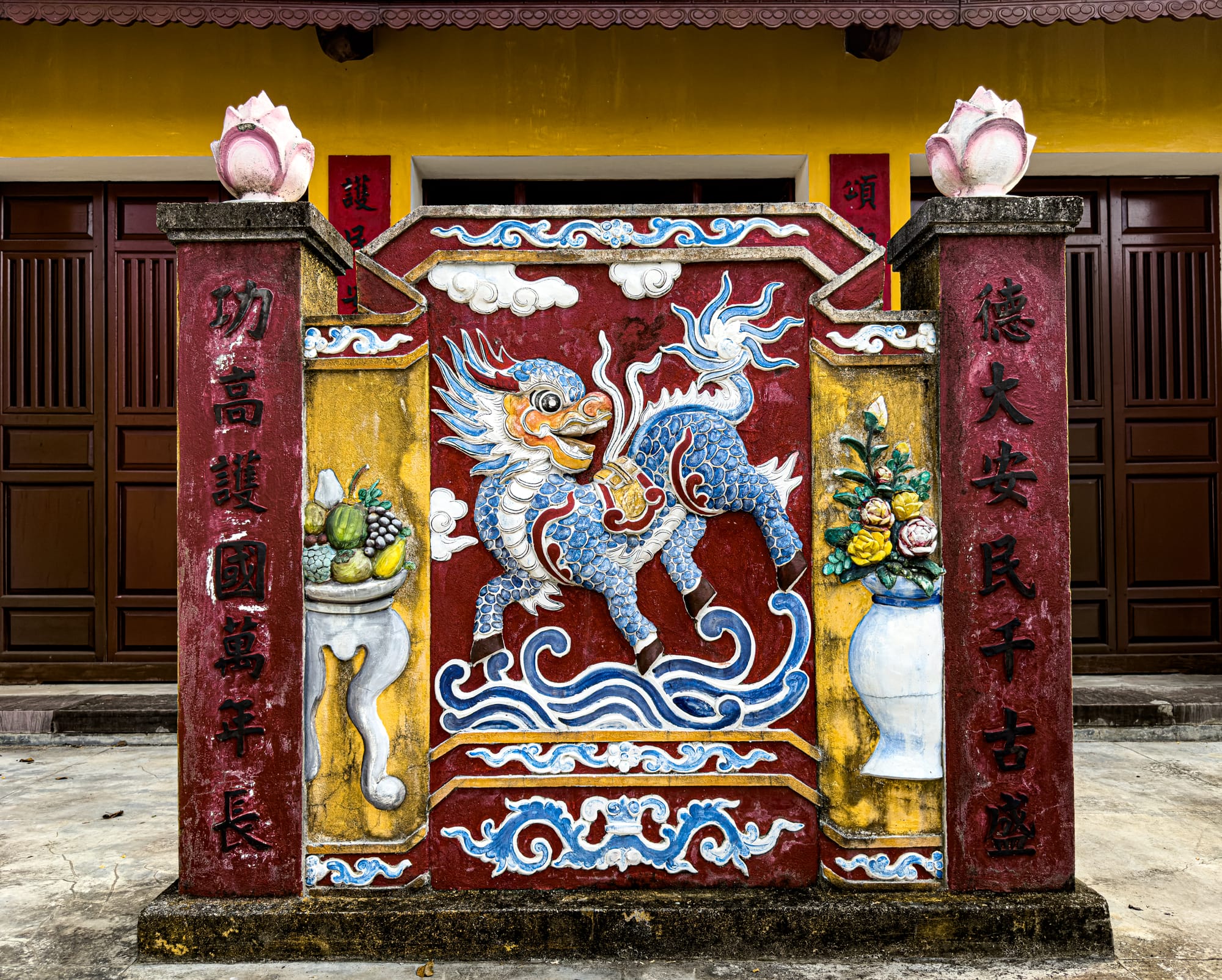 Colorful bas-relief of a mythical qilin creature on the entrance wall of a Chinese assembly hall in Hội An’s Old Town, Vietnam, symbolizing prosperity, protection, and cultural heritage