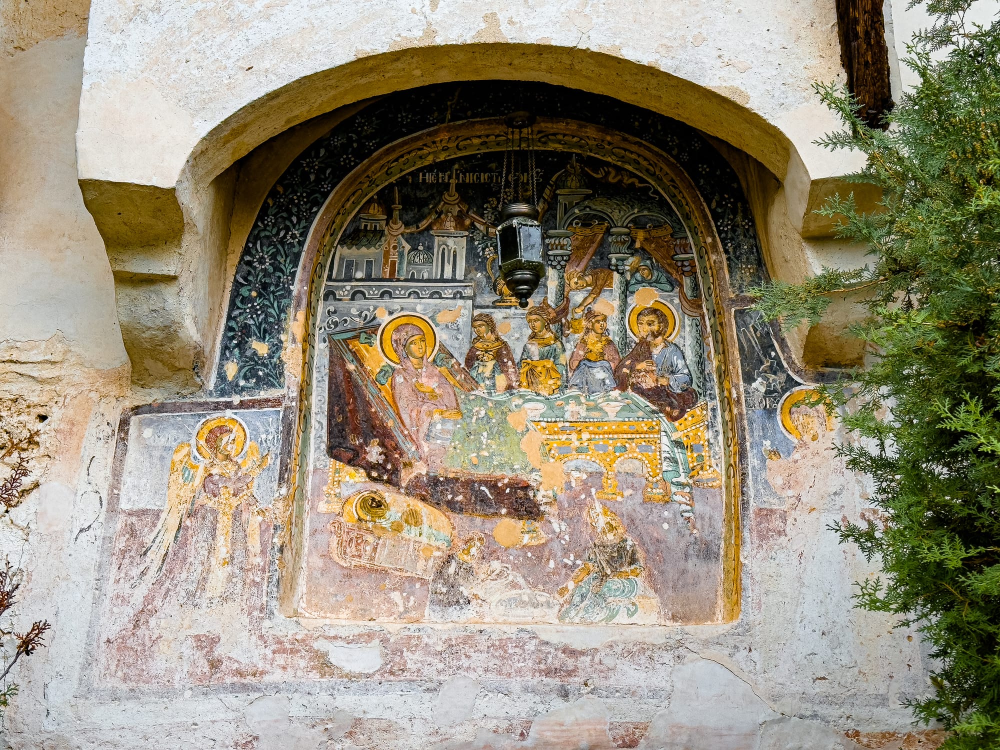 Fresco at Rozhen Monastery near Melnik, Bulgaria, showing a biblical scene with the Virgin Mary, saints, and angels, painted in vivid but weathered colors on an arched wall