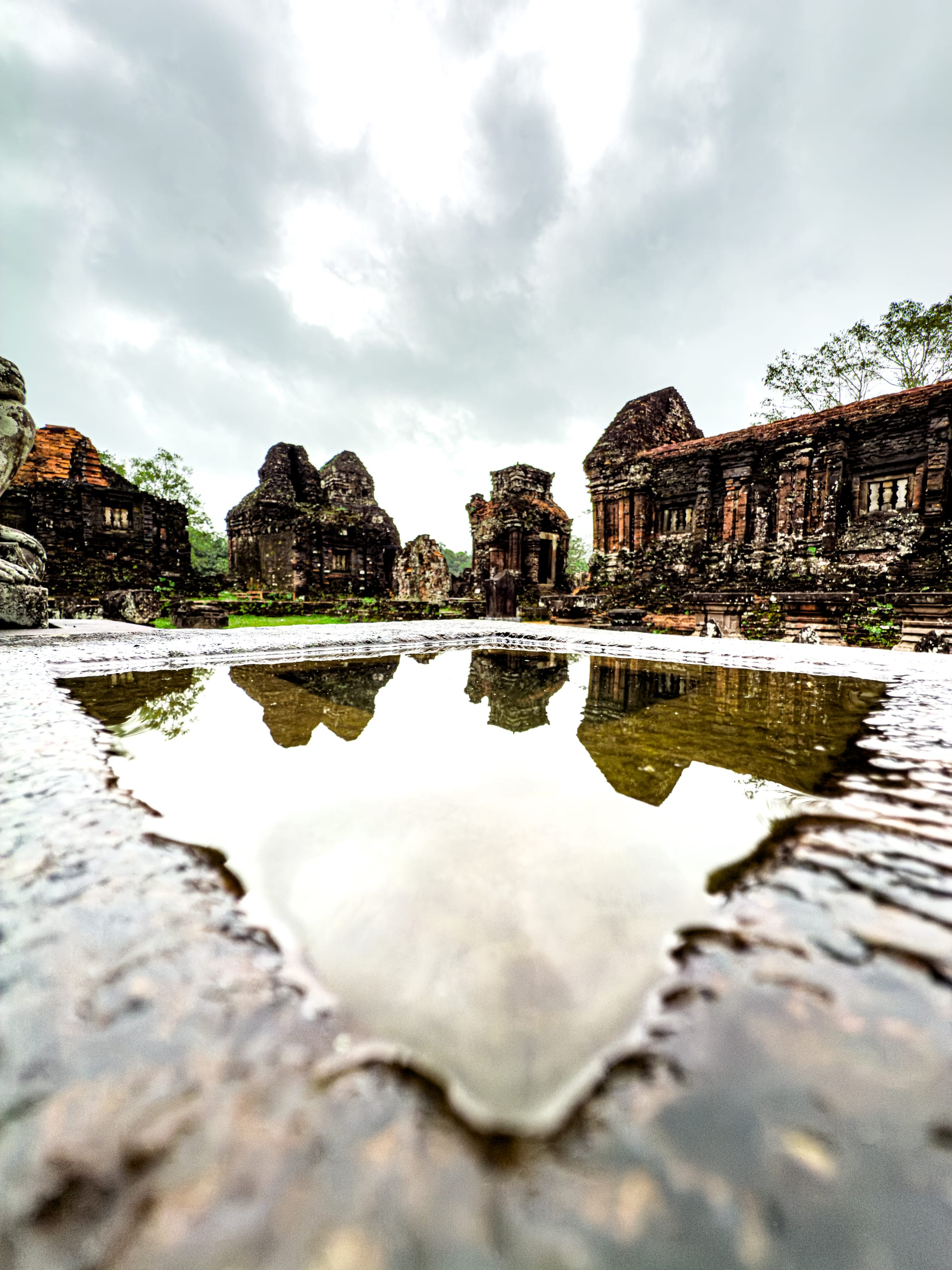 Cham temple ruins reflected in rainwater at Mỹ Sơn Sanctuary UNESCO World Heritage site Vietnam