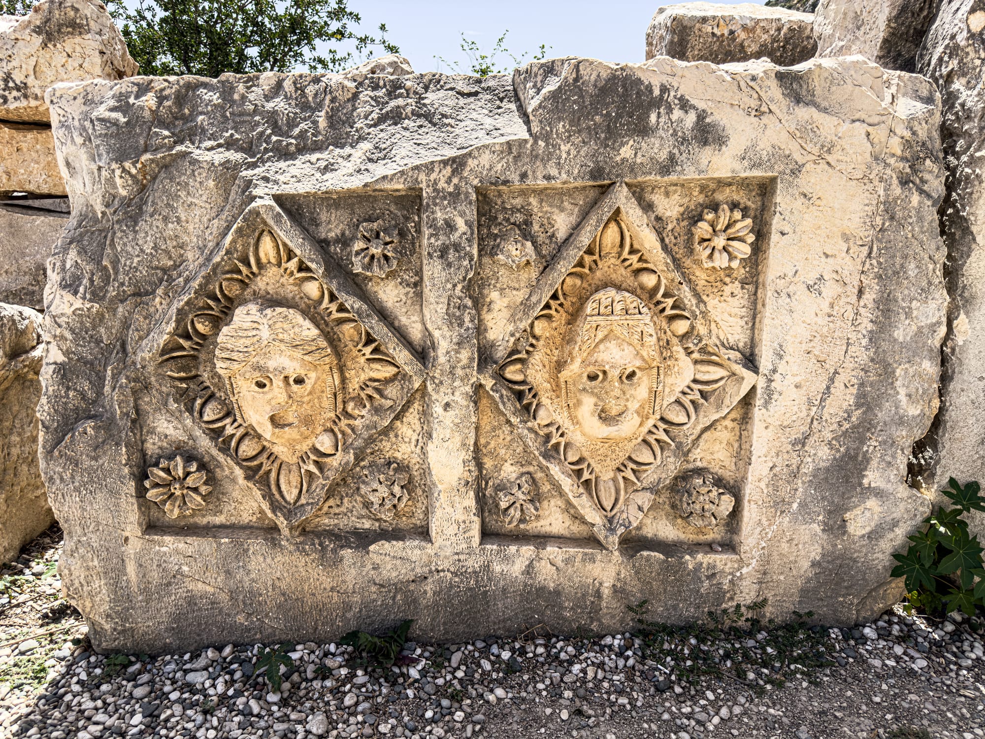 Relief sculpture of two carved theatrical faces with floral ornamentation from the ancient Lycian city of Myra in Demre, Turkey