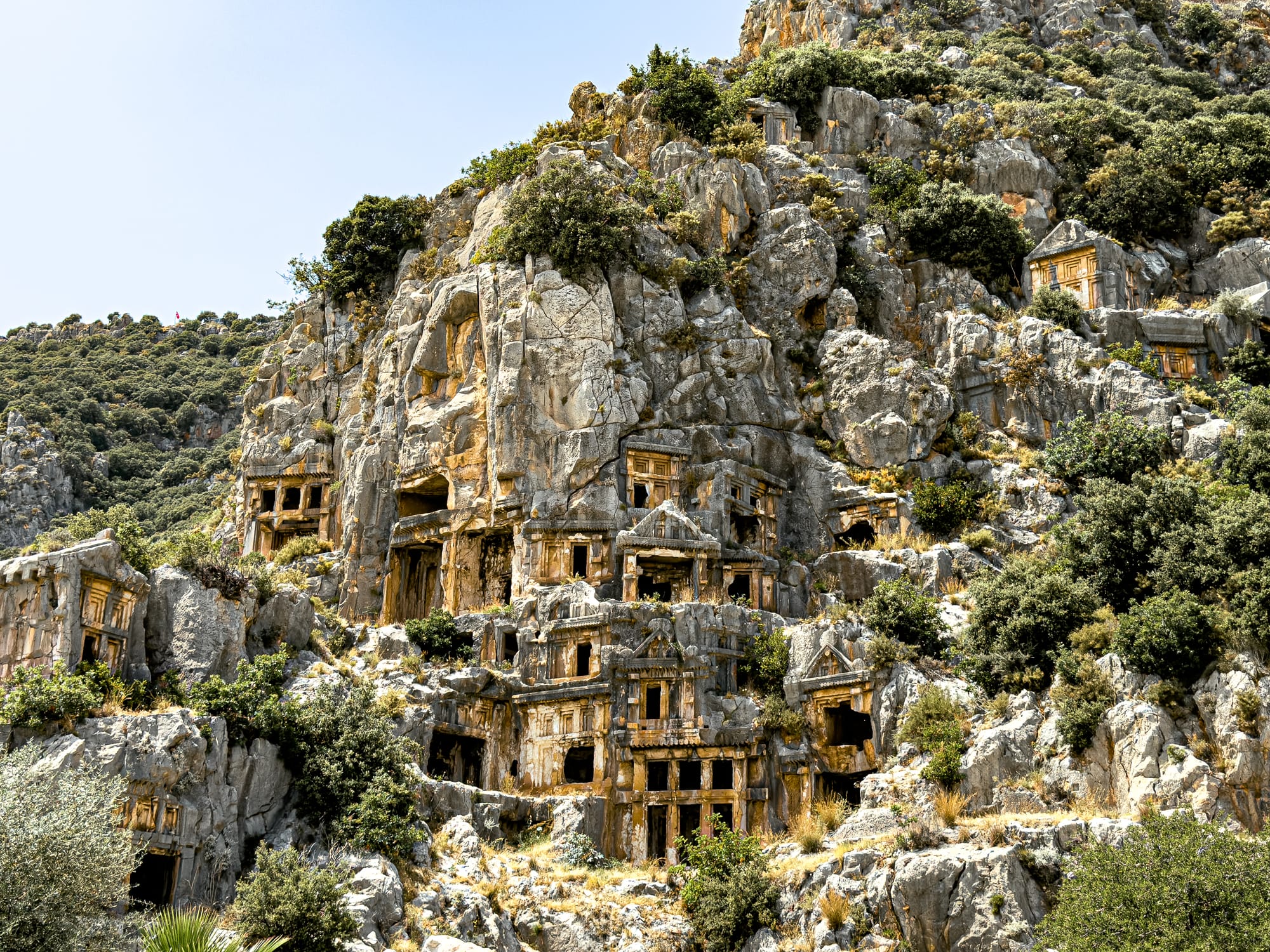 Cliff-cut Lycian tombs at the ancient city of Myra in Demre, Turkey, showcasing temple-style facades stacked into a rocky hillside