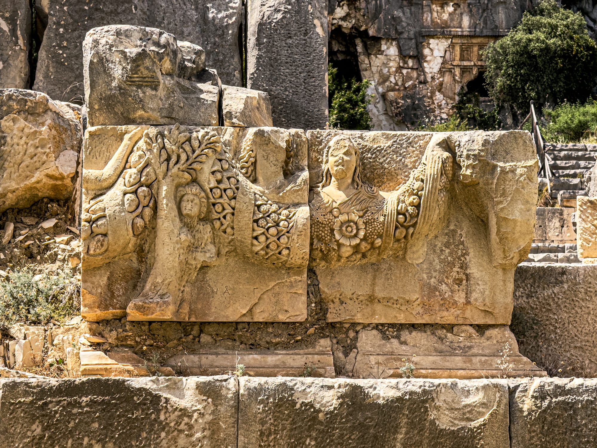 Close-up of intricately carved Roman relief with floral decorations and robed female figures at Myra ancient city in Demre, Turkey