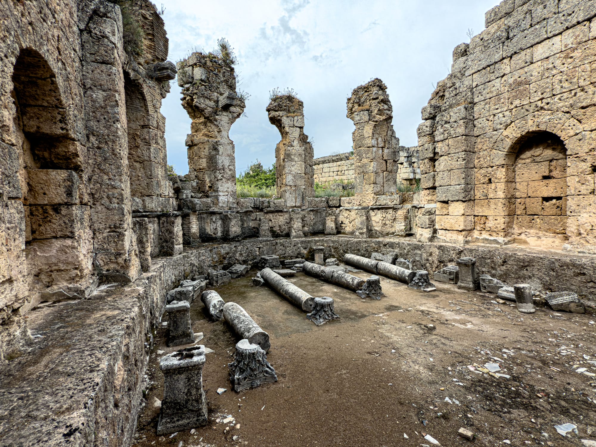 Interior of a Roman bath at Perge with collapsed columns and arched stone niches near Antalya, Turkey