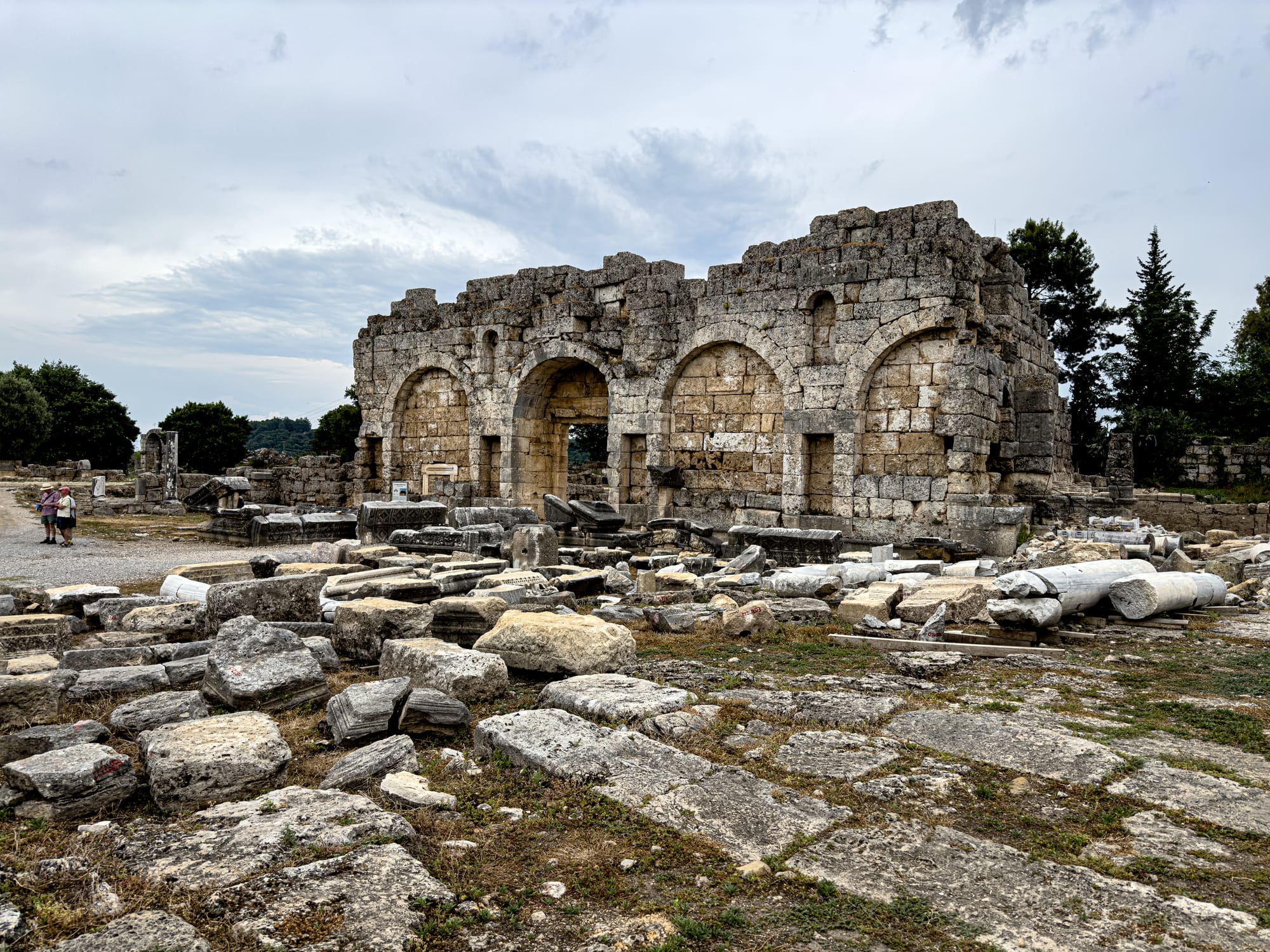 Stone ruins of the Roman baths at Perge with arched entrances and scattered masonry near Antalya, Turkey