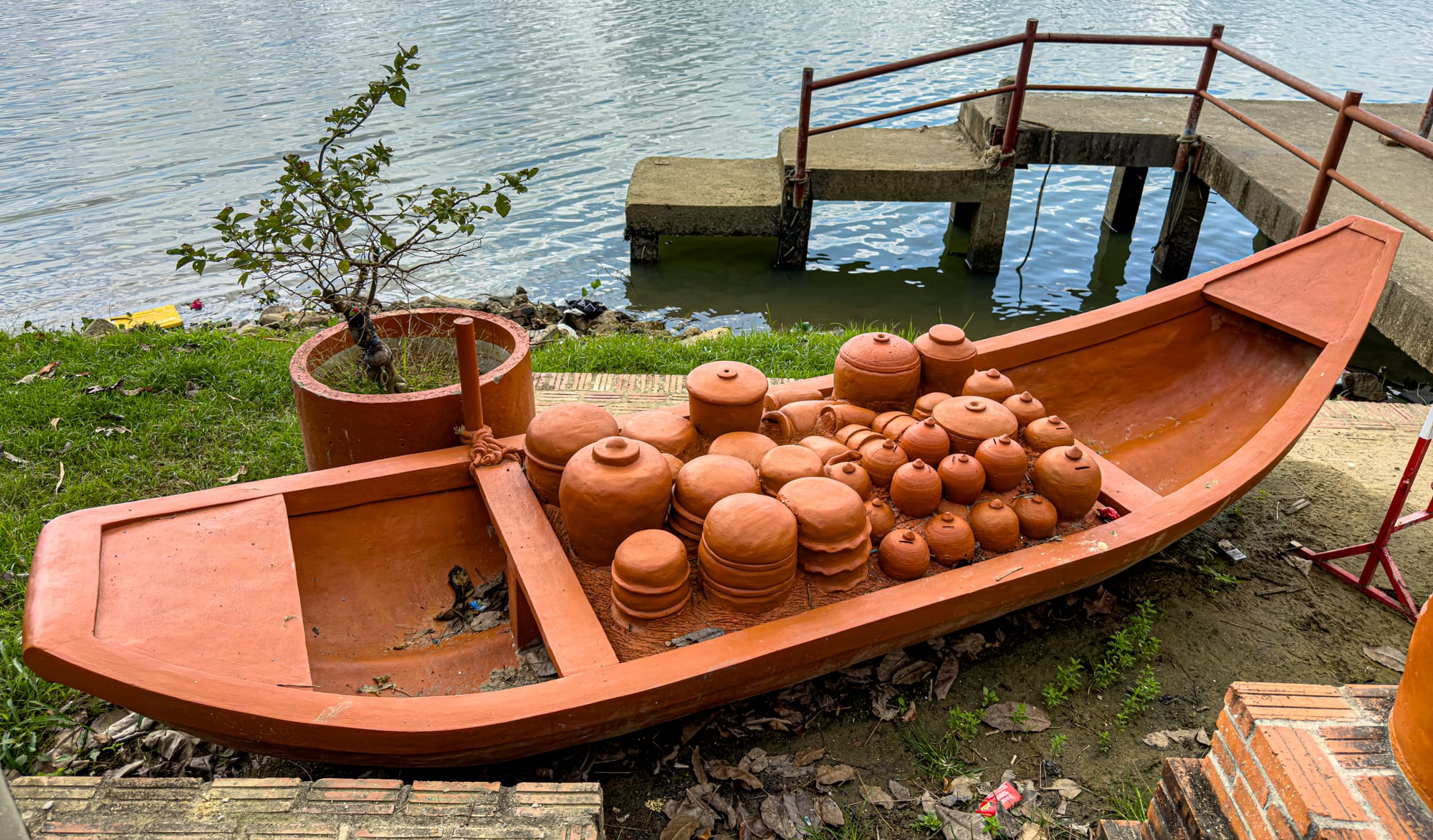 Terracotta boat sculpture filled with clay pots at Thanh Hà Pottery Village in Hội An, showcasing traditional ceramics along the Thu Bon River