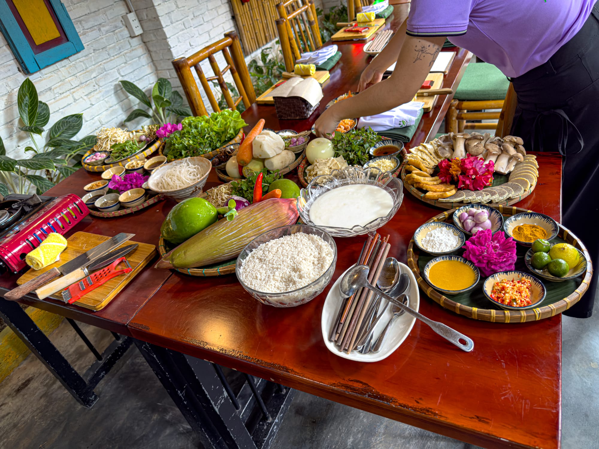 Assorted Vietnamese cooking ingredients and herbs arranged on table at vegan cooking class in Vietnam
