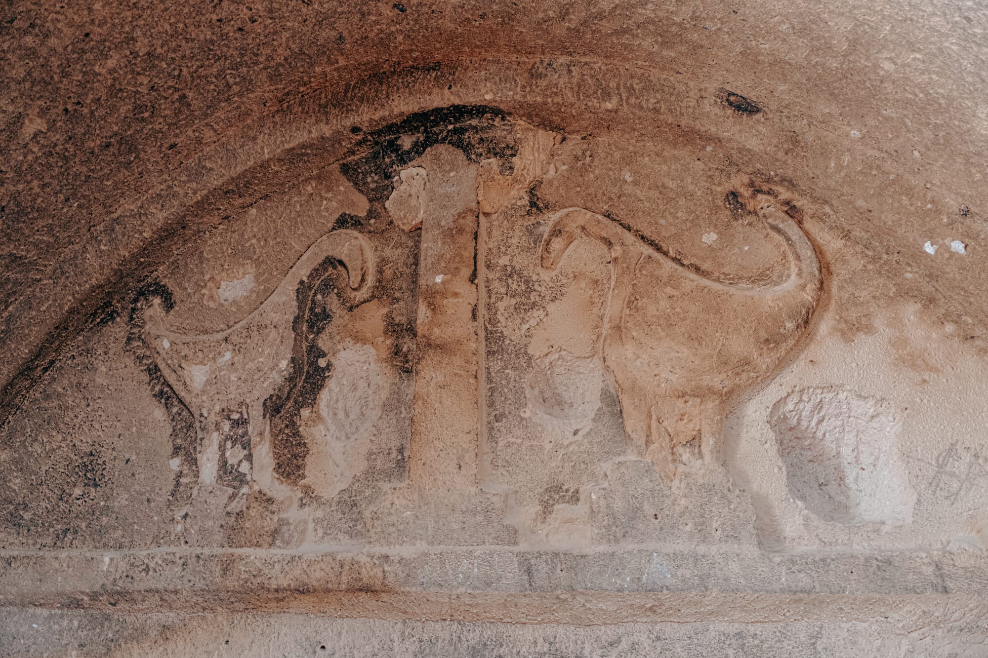 Ancient stone carving of two lion-like creatures facing each other inside Selime Monastery Cappadocia