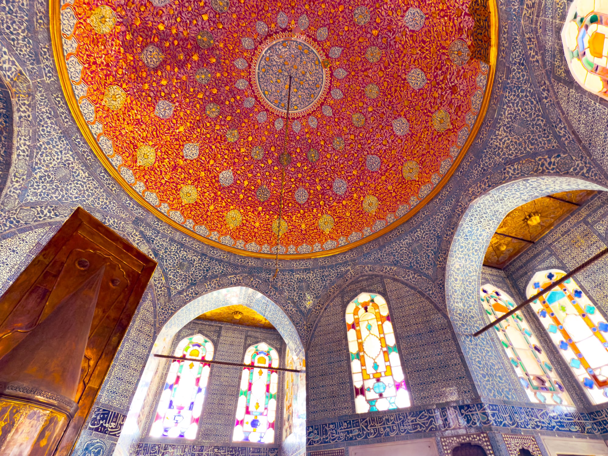 Intricately tiled chamber at Topkapi Palace, with stained glass windows and a vivid red domed ceiling