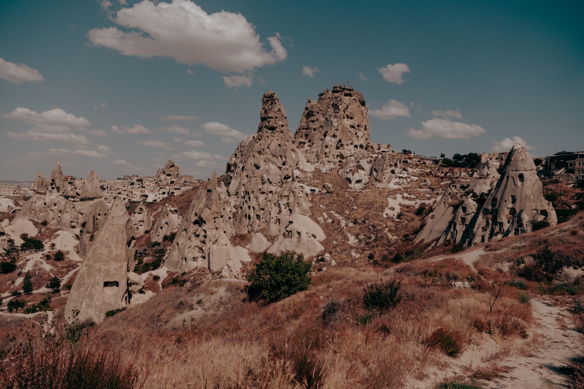 Uçhisar Castle Cappadocia wide view of rock citadel with carved openings and surrounding walking trails