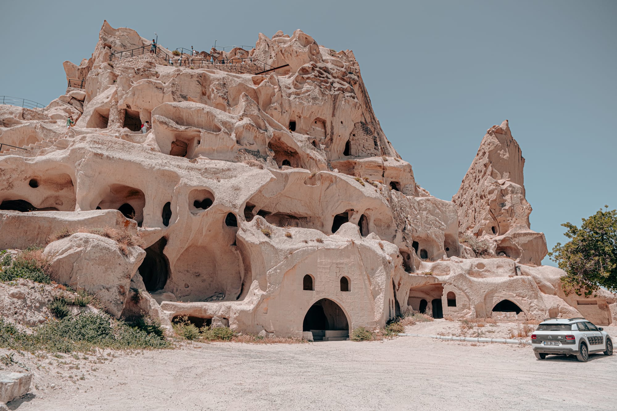 Uçhisar Castle exterior view showing rock face with carved rooms and arched entrances