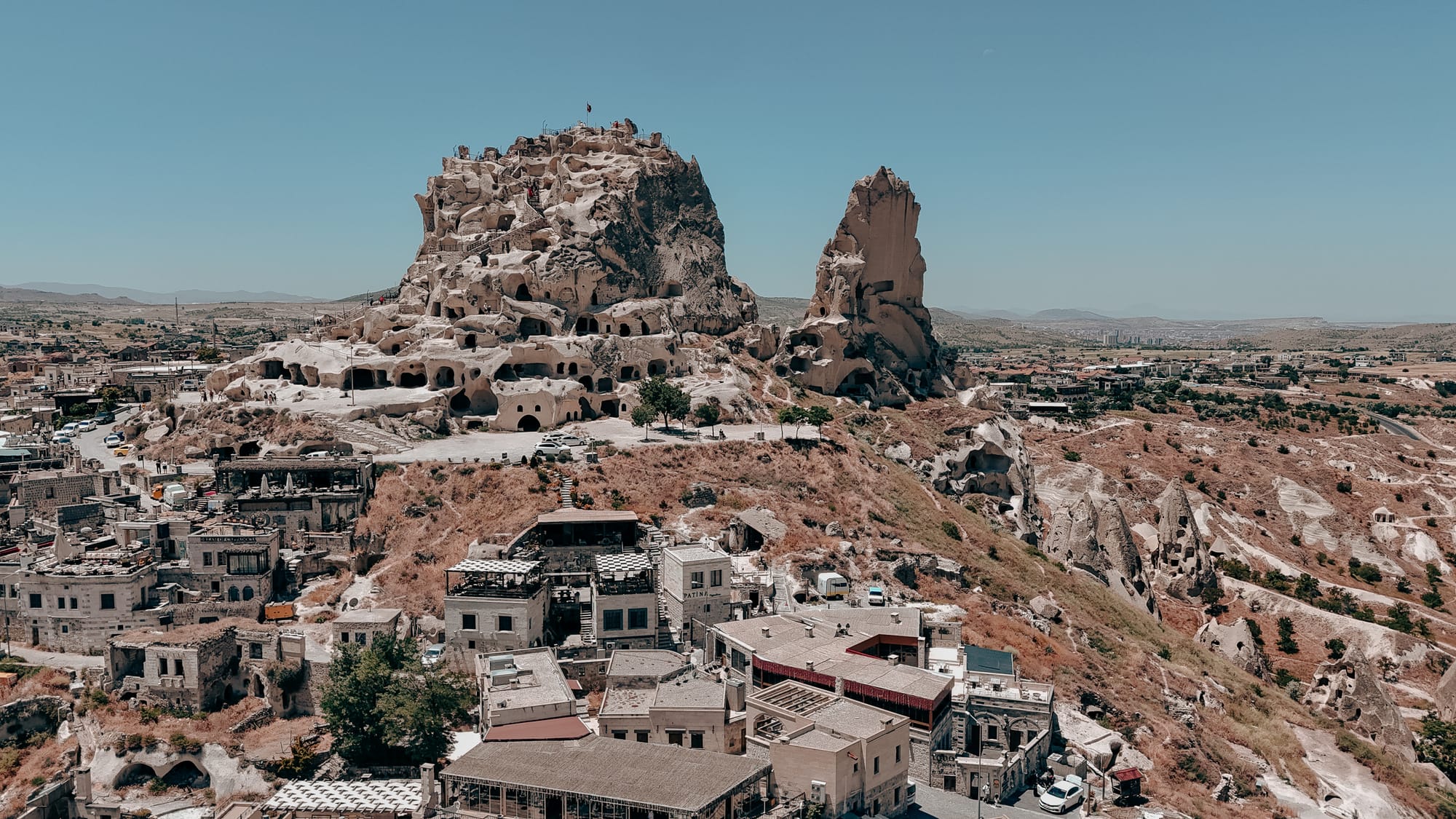 Uçhisar Castle panoramic view with carved rock fortress rising above town and valleys