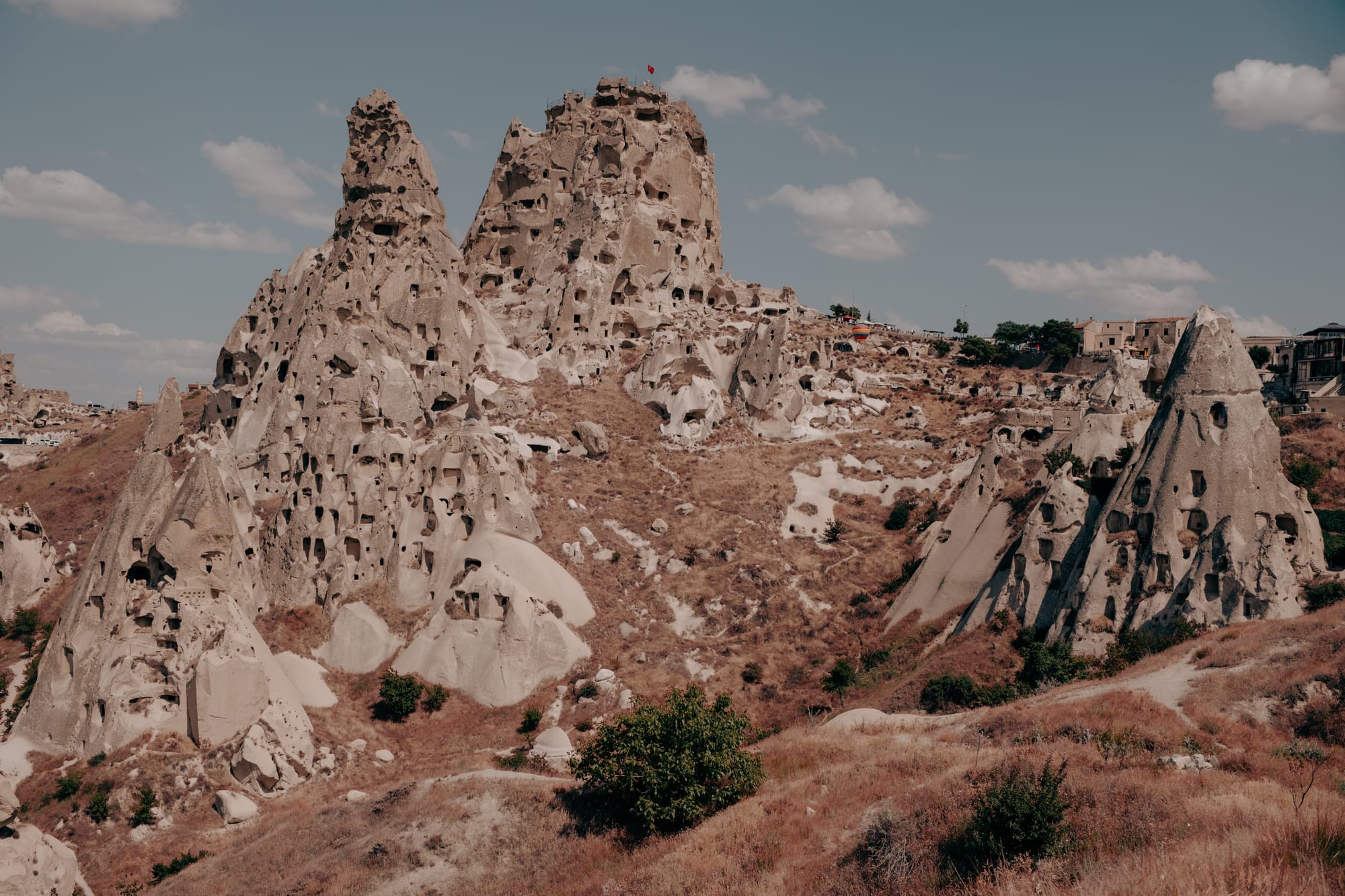 Uçhisar Castle view showing rock fortress with carved rooms and openings across the cliff