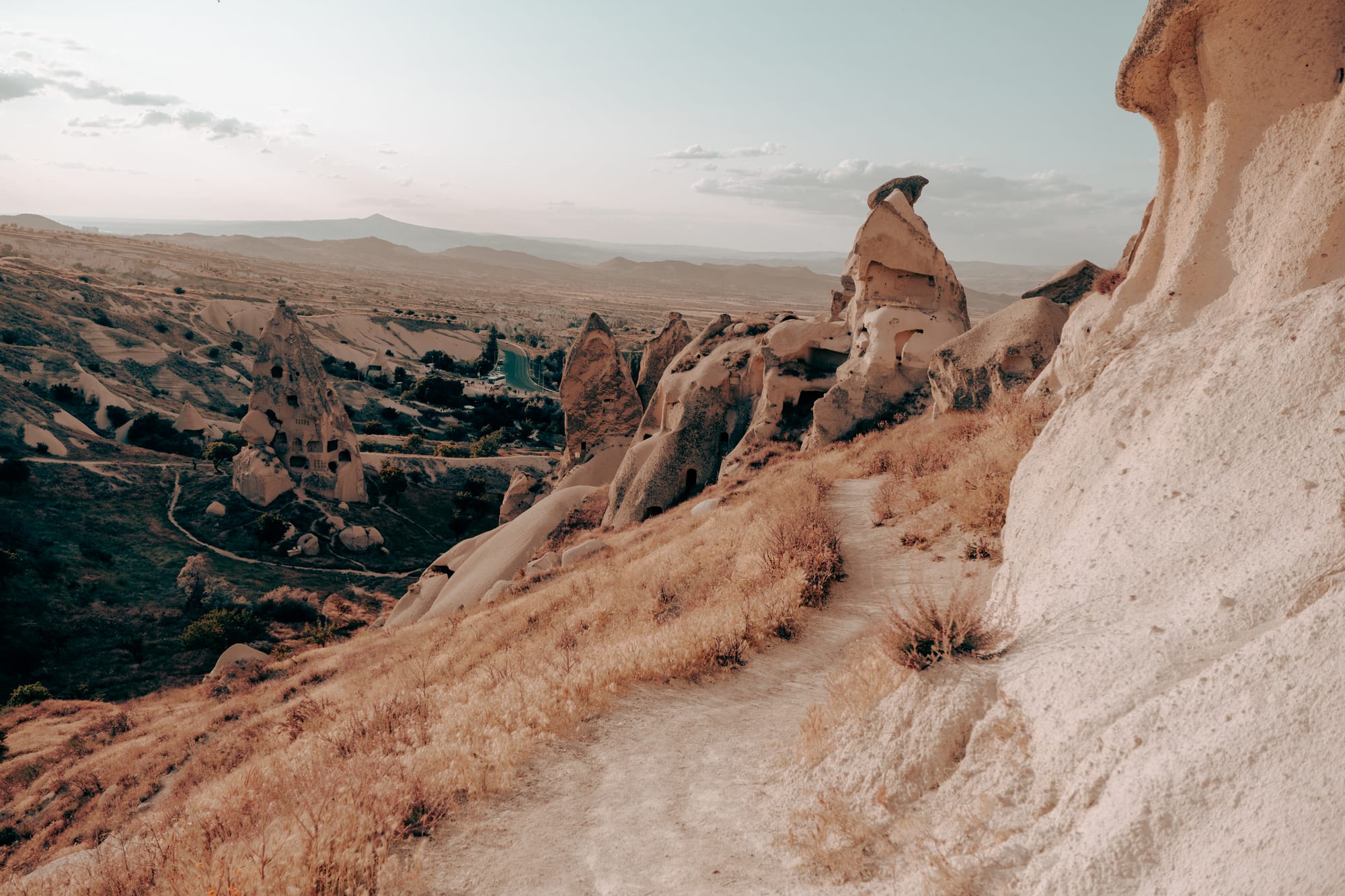 Uçhisar Castle Cappadocia walking trail view with rock formations, carved fairy chimneys, and sweeping valley landscape