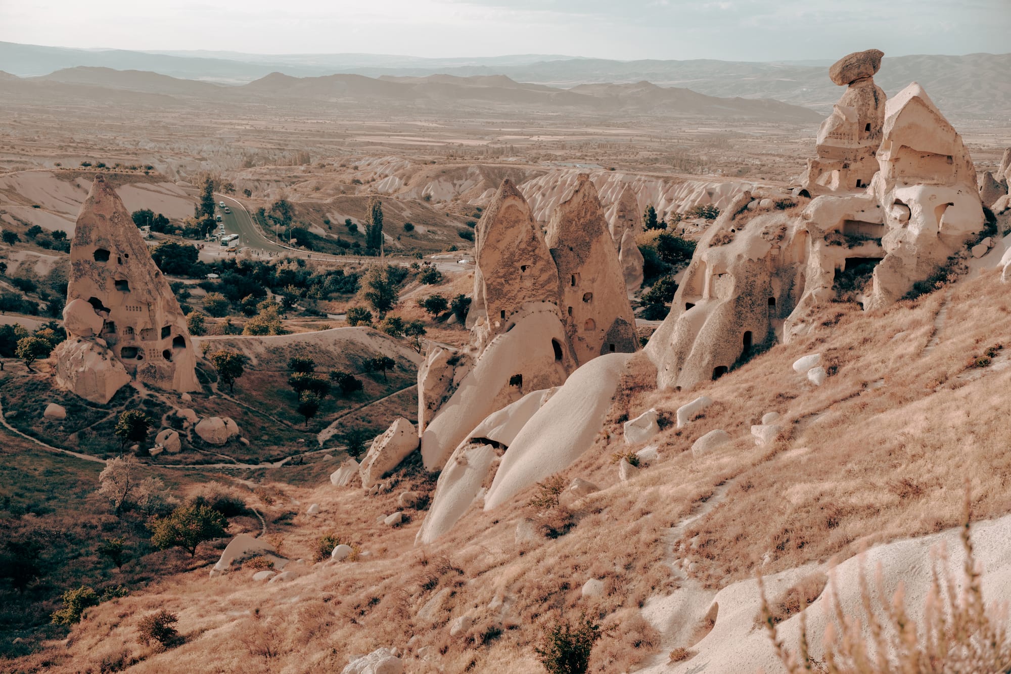 Uçhisar Castle Cappadocia walking trail view with carved fairy chimneys, eroded rock formations, and sweeping valley backdrop