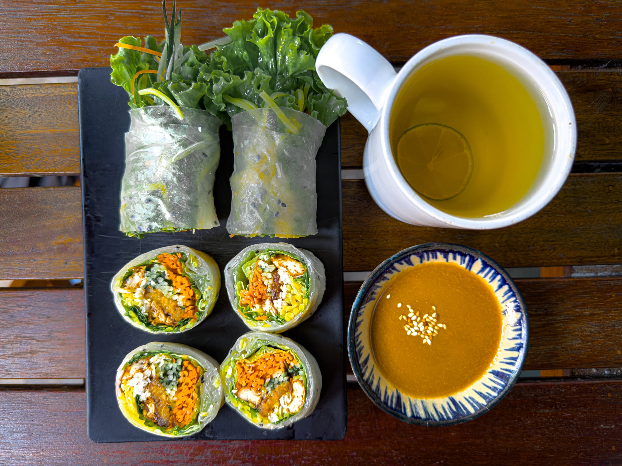 Fresh vegan spring rolls at Chickpea Eatery in Hội An filled with chickpea tempeh, carrots, greens, and herbs, served with sesame dipping sauce and hot lime tea