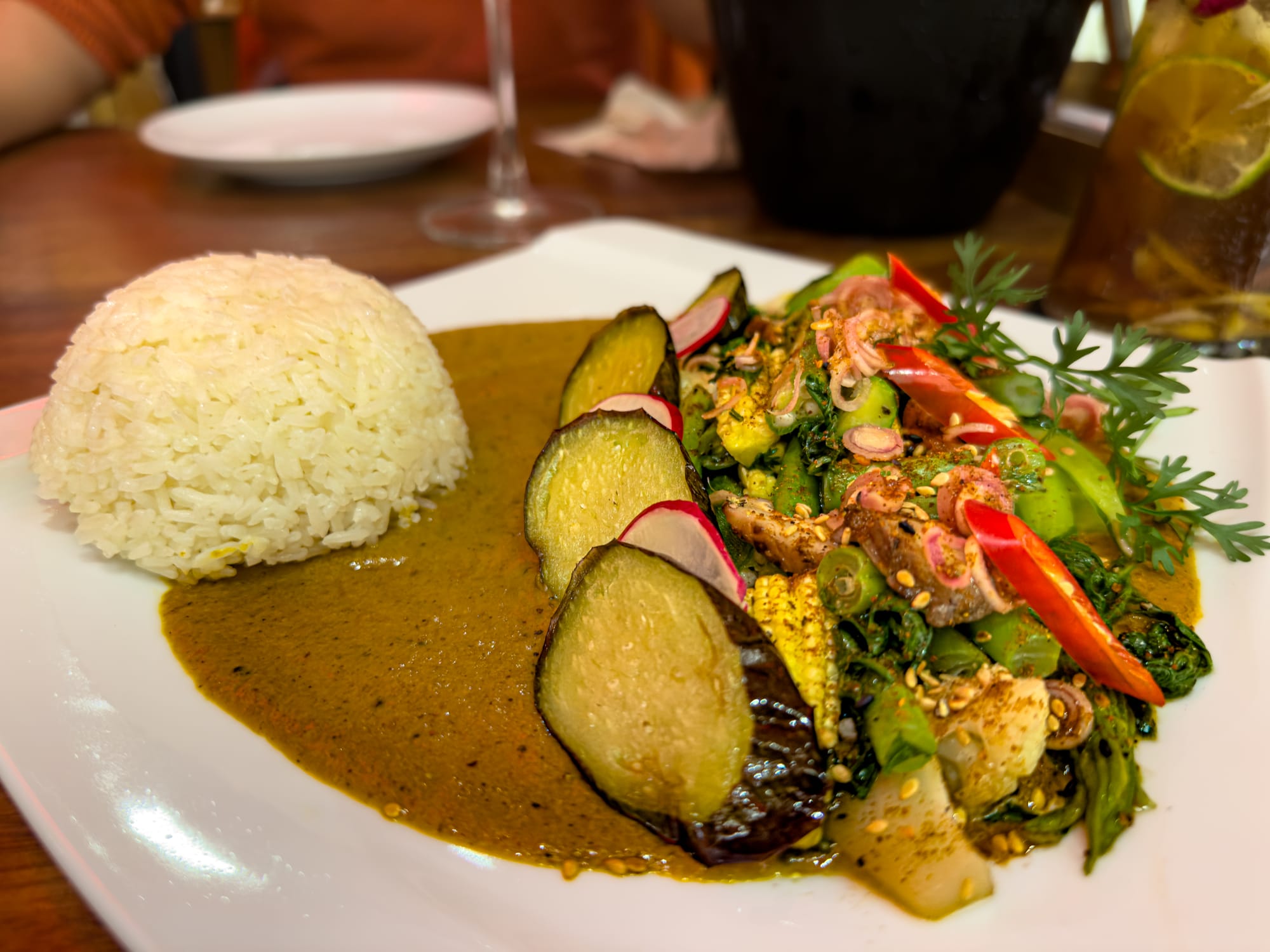 Vietnamese yellow curry with grilled vegetables and jasmine rice at Red Dragon in Hội An, featuring eggplant, greens, and fresh herbs