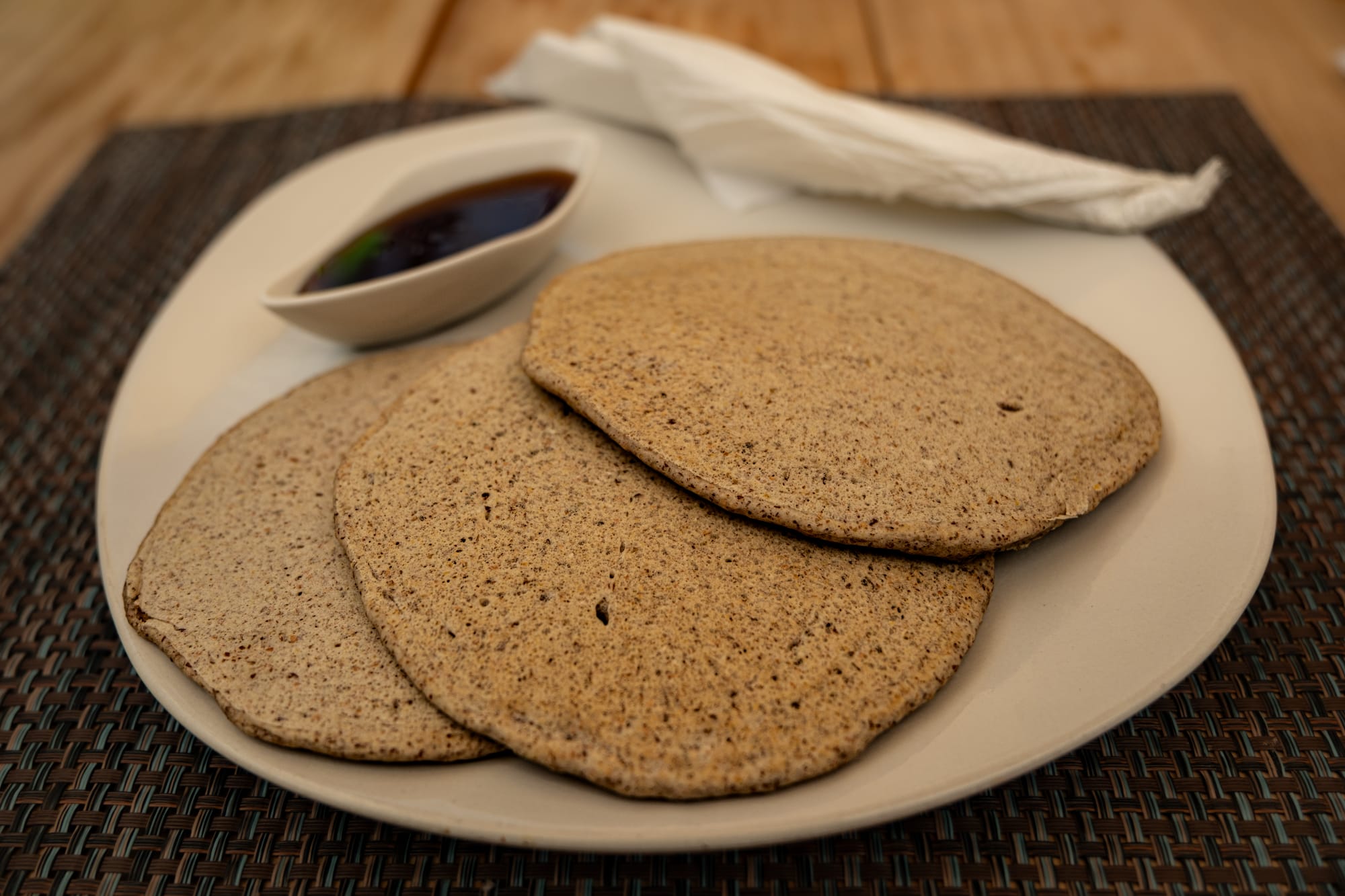 A plate of vegan pancakes from Sweetbeat in San Cristóbal de las Casas, served with a small dish of syrup on the side
