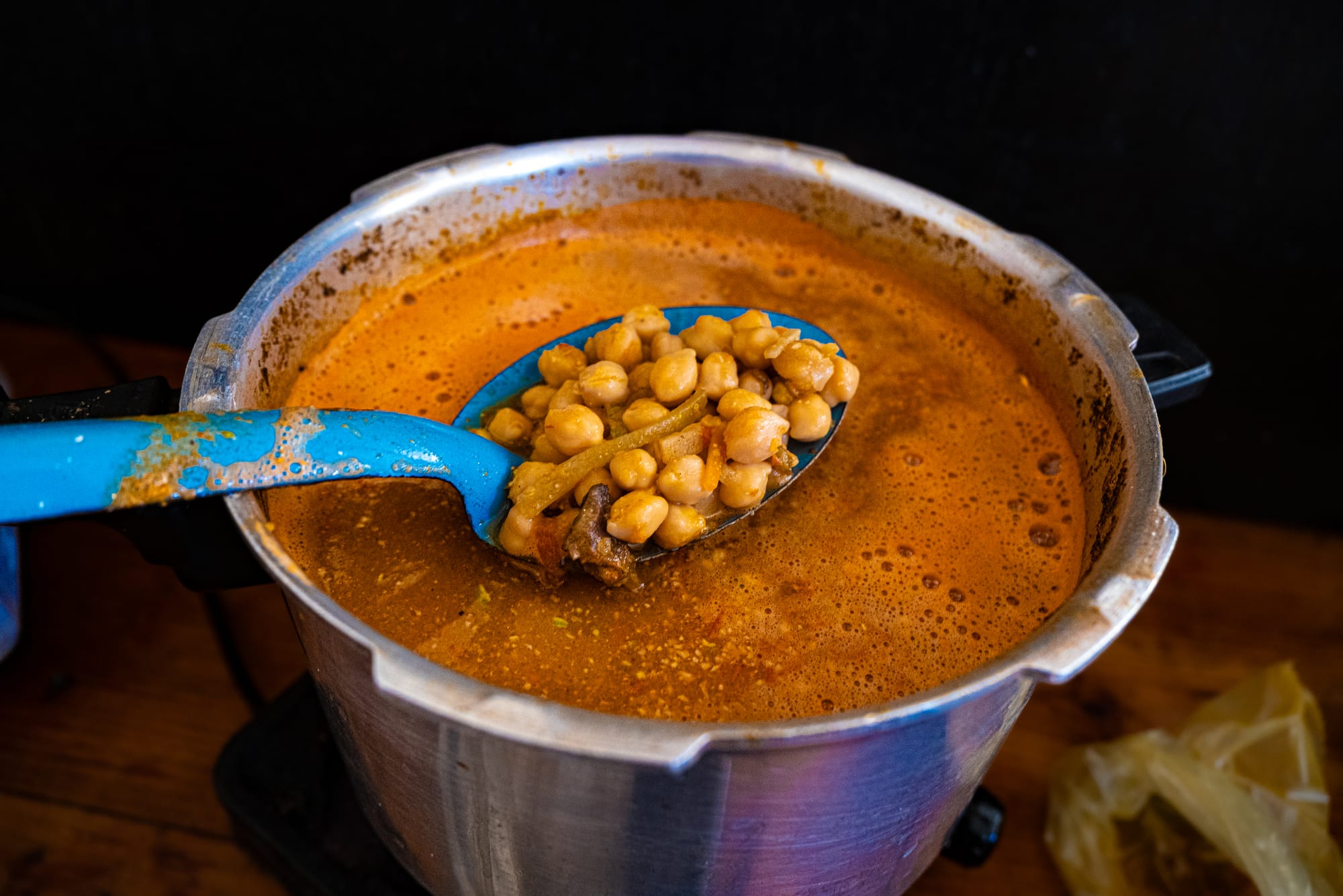 A ladle lifting chickpeas from a pot of simmering vegan stew at Art Libreria in San Cristóbal de las Casas