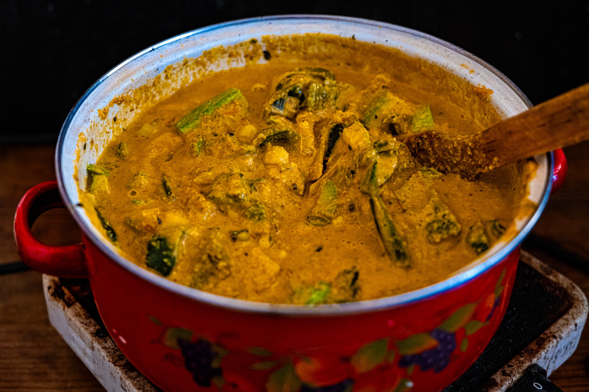 A pot of vegan rajas con queso cooking at Art Libreria in San Cristóbal de las Casas, with poblano strips and vegetables simmering in a thick golden sauce
