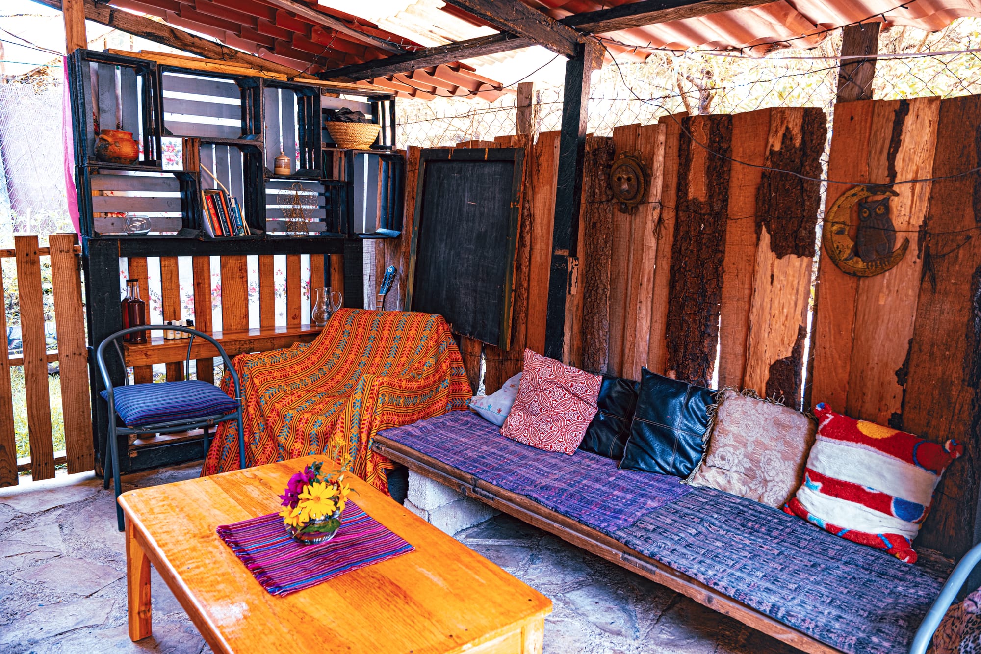 Cozy outdoor seating area at a cacao workshop space in San Cristóbal de las Casas, featuring rustic wooden walls and handmade textiles
